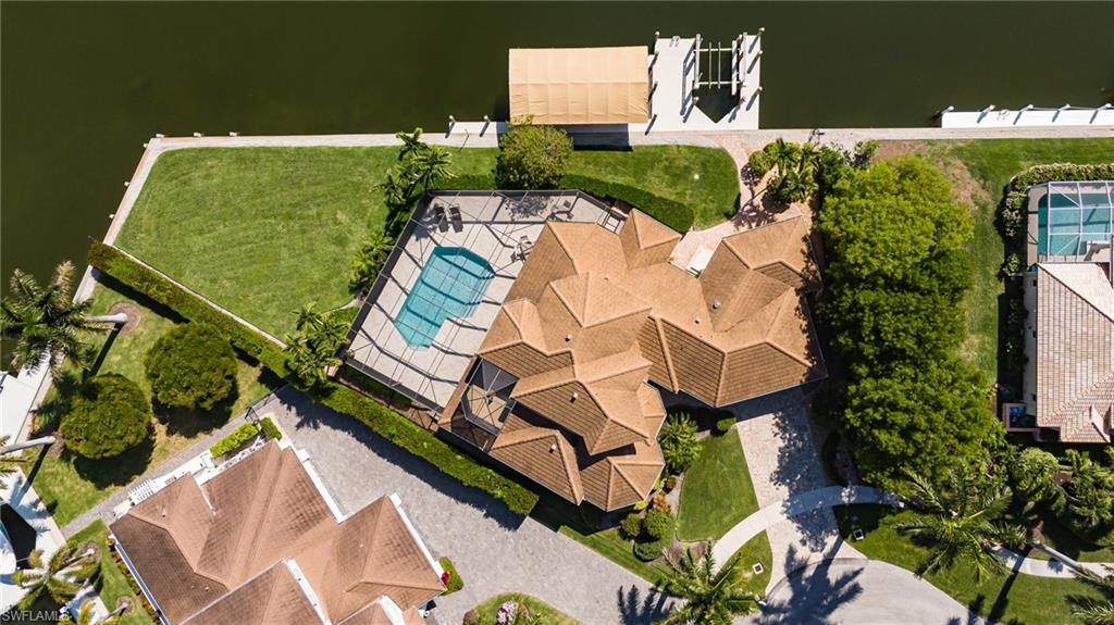 Rarely available, this extraordinary Gulf-access waterfront estate sits on a spectacular oversized tip lot with 205 feet of direct waterfront and breathtaking panoramic converging water views. Tucked away on a quiet cul-de-sac, this custom two-story residence offers the ultimate Southwest Florida boating lifestyle with bridge-free access to the Gulf, two private docks, and dual boat lifts providing quick access to open water.

Designed for both luxury and comfort, the home features 4 bedrooms, 4.5 baths, soaring volume and tray ceilings, new tile flooring, and expansive living spaces filled with natural light and stunning water views. The updated chef’s kitchen includes custom cabinetry, double ovens, cooktop, oversized pantry, and spacious gathering areas ideal for entertaining.

Both upper and lower-level primary suites feature beautifully updated baths, while the upstairs retreat offers a private sitting area and waterfront lanai. A separate guest suite with private lanai access (currently used as a gym) makes an ideal office, cabana suite, or private retreat.

The newly retiled screened lanai and resurfaced pool create a true waterfront sanctuary perfect for relaxing, entertaining, and enjoying peaceful canal views. Additional features include electric hurricane shutters and impact glass.

A rare opportunity to own one of the area’s most impressive waterfront properties combining luxury, privacy, boating, and unforgettable views.