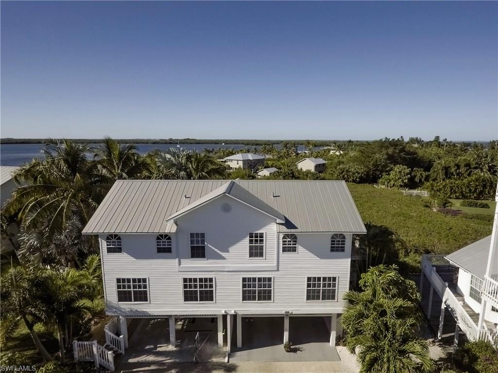 Tropical 3/2 home in Seagull Bay on Little Bokeelia Island in northern Bokeelia. This home features hand painted murals, custom shell mirrors, an intercom/music system throughout, an upgraded kitchen with new warm cabinets and Silestone countertops, a new shower in the master suite and many more upgrades. The home's lanai has a western exposure for great Florida sunsets. The boat slip with 10,000 pound lift provides quick access to the outer islands and the Gulf. You can be enjoying a burger at Cabbage Key in approximately 20 minutes! The Seagull Bay Community has a rare for Pine Island - a community private beach on the shores of Charlotte Harbor. Relax on your private beach with your toes in the sand while the dolphins swim by, the mullet jump and the pelicans dive. Very low HOA dues. This home is truly a "must see." Call for a private showing today.