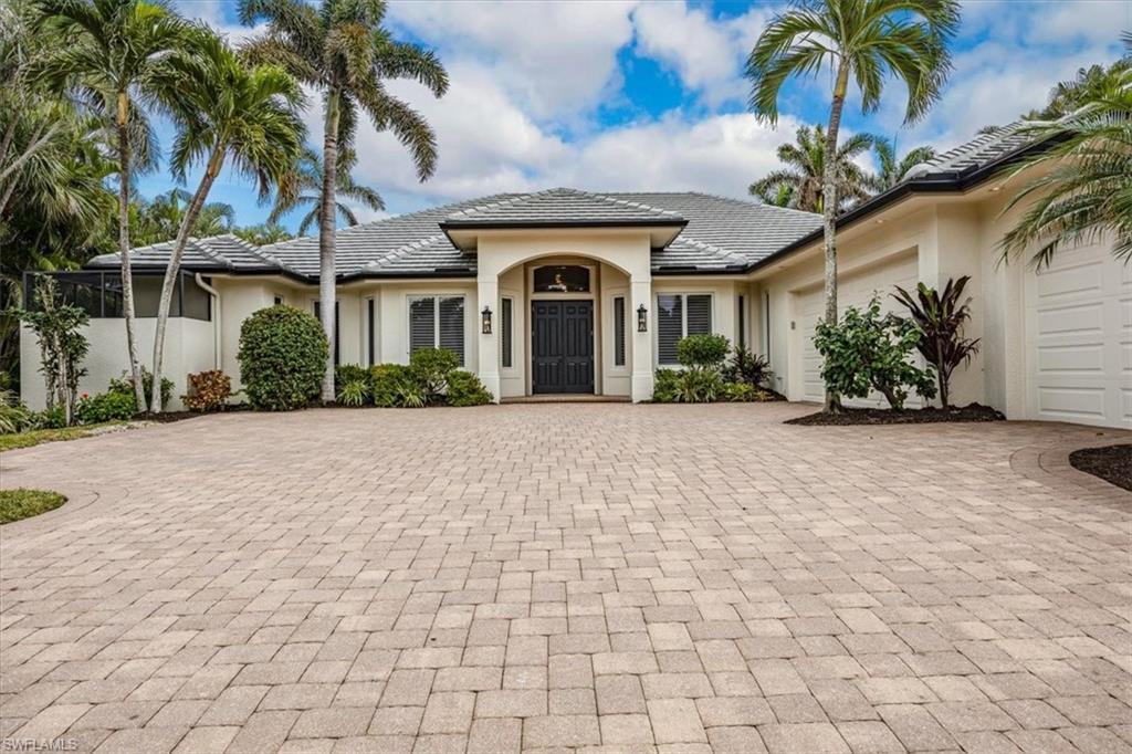 Welcome home to this recently refreshed custom pool/spa home in the popular "West of 41" Moorings community.  This four bedroom, plus den, four and a half bath home all on one level with a THREE car side loaded garage is set back on a .37 acre lot, allowing for an expansive circular drive and entry way (with plenty of parking). This custom home, built by 41 West custom home builders in 2005, sits high and dry at 12' (11' 7" at the garage level) and has never been affected by storm surge flooding.  It has many features of newer homes, yet is available at a substantially lower entry price. It presents a unique buying opportunity as it is priced similarly to renovated 1970s homes, which are 30+ years older and are more susceptible to flooding. The home features high ceilings throughout, crown molding, tile floors in the main areas and 2 bedrooms, new carpeting in 2 guest bedrooms and Andersen impact windows (2005) throughout the residence, with hurricane protection (roll down shutters and hurricane rated protection for the outdoor covered lanai), a 20kw generator, a 500 gallon buried propane tank and a 2023 flat tile roof.  This home has a split floor plan, with the primary bedroom suite (with two walk-in closets) and separate den/office on one side of the home and three additional en-suite bedrooms on the other side. The chef in the family will love the gourmet kitchen with custom wood cabinetry, granite countertops, gas cooking and a large center island. Outside is an inviting gas heated pool and spa, two separate covered outdoor living areas and an outdoor kitchen.  This home is situated near the Moorings' private beach park (and is eligible for the private Moorings Beach Park optional membership - ONLY for Moorings residents) and is conveniently located close to the shops and waterfront dining at Venetian Village, downtown 5th Avenue/3rd Street and uptown Mercato outdoor shopping and dining.