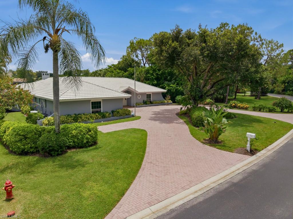 Comfortably modern, completely handicapped accessible, this lakefront gem is a true find!  Hand-picked location, this is the Developer's personal residence broken ground in 1977.  Single story "ranch" style this is the very first Estate Pool home built in the prestigious Naples Bath and Tennis Club.  Nestled in town, 3 miles from the beach and close to everything, its gated and very well-maintained community. Purchased in 2020, owners continuously improved the residence room by room, from "floor to ceiling."   Greeted by convenient circle driveway w/ interlocking pavers, 740 Bald Eagle's Battleship Grey color with white trim, Boldy stands out in the green park like setting.  The foyer with coat closet, greets guests to sweeping lake views, hard woods, trims and finish work catches your eys and details abound.  An elevated site that has never flooded, has new high impact windows and sliding doors throughout the house. Bamboo wood flooring connects all the bright living space. Other significant improvements are made in the kitchen, the laundry room and in the office space which includes custom built desks and cabinets. It is roomy enough to double as an additional bedroom. A wonderful feature of the home is the connection with the outdoor space - The expansive sliding glass doors create seamless indoor/outdoor living, opening to the newly tiled pool deck and the resurfaced saltwater pool and the integrated spa. A Generac generator and a 1,000-gallon fuel tank guarantee that electricity will never be lost during a hurricane. Built-ins include encased electric fireplace, wainscoting, custom glazed trim, custom shelves; additionally, Cedar plank ceilings, Sunroom, formal dining room. 2 car garage, Florida-White Barrel tile roof, side entry garage, pool bath and luxury "Bump outs" in the exteriors wall's design extend the sense of space, and this house lives much larger than its 3000 enclosed under air.  Built in hot tub with pool and additionally, a free stranding Specialized Therepautic Walk in Spa  is included for your comfort. This home is vacant and ready to go.