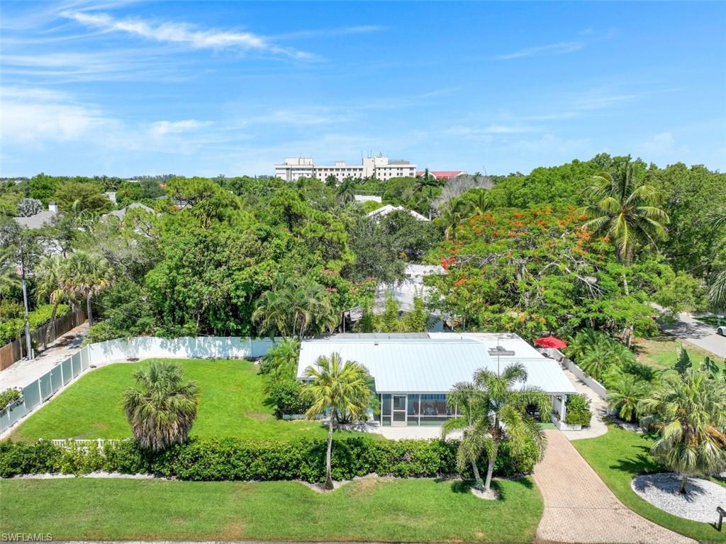The ultimate in location, less than 3 blocks to the beach! Nestled on a quiet, tree-lined street just a short stroll to Naples' pristine beaches and all that Downtown Naples has to offer.  Wonderful lot with alley access.  Perfect for development.  Home did not incur any wind or water damage from Hurricane Ian (elevation at 11').  LOT STUDY ATTACHED PROVIDED BY MHK.    This charming well-kept home is on a spectacular corner lot. There is a large grassy yard that backs up to the alley, which provides access to the property through a private gate. Two screened porches allow for a variety of uses. Whether relaxing, entertaining or dining everyone has their own space. If open air is what you desire, the front terrace is perfect to enjoy the sun.  A truly special piece of property.