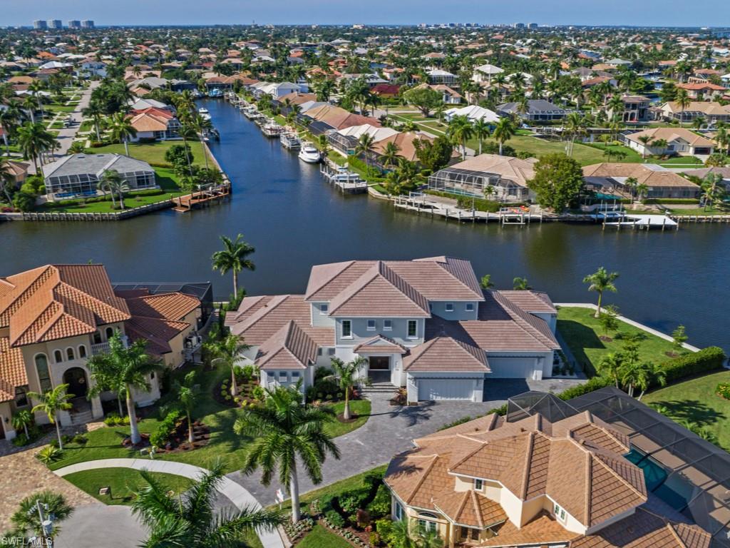 Now ready for immediate occupancy! Pull your yacht up to the new 215’ seawall at this extraordinary residence located on a vast tip lot! Enjoy the outdoor shower to refresh before moving on to the oversized pool, outdoor living room w/ fireplace, kitchen & electric roll down screens. Fine coastal living, 4,700 sf of air conditioned luxury, professionally designed & furnished, with custom bed clothes & window treatments, mahogany wood front door & interior hand rails. The gourmet kitchen has custom Amish cabinetry & beamed ceilings with inset bead board. Bead board ceiling accents are used in most areas of this home. The master bedroom suite with huge custom closet, bath with a walk-through rain shower, dressing tables & soaking tub. 500 gallon propane tank services stove, pool, grill & fireplace. Unique to this estate, the casita has a private entrance, bath & covered lanai for your special guests! Upstairs, your guests will enjoy 3 bedrooms, 2 baths, a huge common area & covered lanai with magnificent views of multiple converging waterways & Marco Island! Park your cars in the 4-car garage with an air conditioned storage area upstairs & convenient space for pool equipment, too!