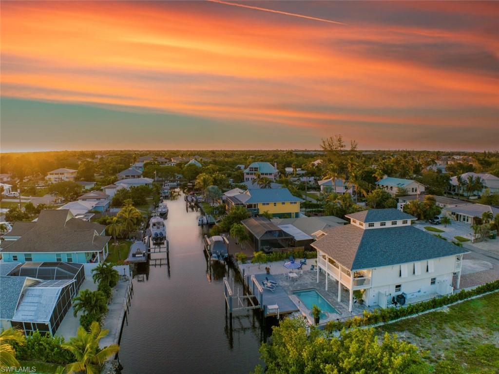Enjoy gulf-access waterfront living in the hip Bayshore Arts district of downtown Naples at Sailfish Shore! This classic Florida Keys style home is newly renovated in a contemporary style and decorated with a cool neutral coastal color palette. The abundance of outdoor living space is ideally setup for enjoying time outside on the water. Arrive by boat and hop right into your heated pool and hot tub. The large covered lanai has an outdoor kitchen with mini fridge, sink, bar, TV, and comfortable cushioned outdoor living furniture. Chaise lounges on the dock are perfect for sunning and a pool bathroom downstairs offers convenience for time spent outside! The home also has a covered porch overlooking the water on the second floor, off the main living area that is perfect for quiet mornings with coffee or dining without venturing downstairs. The location is walking distance to restaurants, bars and coffee shops including popular local attraction Celebration Park, which is a food truck park with outdoor bar that often has live music right on the water. Local beaches in Olde Naples are within 3 miles of the house. The Gulf of Mexico are accessible via the waterway behind the house.