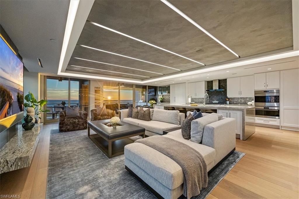 Welcome to 1701 Mystique, the crown jewel of Naples’ most prestigious high-rise, where custom craftsmanship and coastal sophistication meet on a grand scale. More than 5,500 square feet of reimagined living space capture sweeping views of the Gulf through floor-to-ceiling windows that flood the home with natural light.  One of Naples’ rare condos offering a private three-car garage plus an additional deeded space — four coveted parking spots in total. Every element has been thoughtfully curated—from Legno Bastone flooring and Venetian plaster ceilings to bespoke millwork and hidden cabinetry that add architectural refinement throughout. The great room is anchored by a dramatic stone and hammered-metal fireplace wall and complemented by a dedicated wet-bar, lounge, and 392-bottle temperature-controlled wine room—an ideal setting for both entertaining and everyday living. The gourmet kitchen features Wolf and Sub-Zero appliances, gas cooking, quartz countertops, and a striking Black Panther Leather stone buffet that blends artistry and performance. A spacious lanai with hurricane shutters includes a lounge area, dining space, and built-in grill, seamlessly extending the kitchen and great room for effortless indoor-outdoor living. The primary suite is a serene retreat with breathtaking beach vistas, a spa-inspired bath, and custom-designed closets for both beauty and function. One of the four additional bedrooms serves as a private office with 180-degree golf course views, and a hidden closet concealed behind a wall of built-in cabinetry. Smart-home comforts include remote-controlled drapes and blackout blinds in all bedrooms, dual dryers, and private elevator access. Mystique offers a lifestyle beyond compare with 24-hour concierge and staff, a resort-style pool, private spa suites, theater, fitness and wellness center, billiards and social rooms, guest suites, and tennis courts—all within Pelican Bay’s exclusive beachfront community, featuring two private beachfront restaurants and proximity to Naples’ finest shopping, dining, and cultural destinations. This is more than a home—it is a statement of design, exclusivity, and modern coastal living at its highest level.