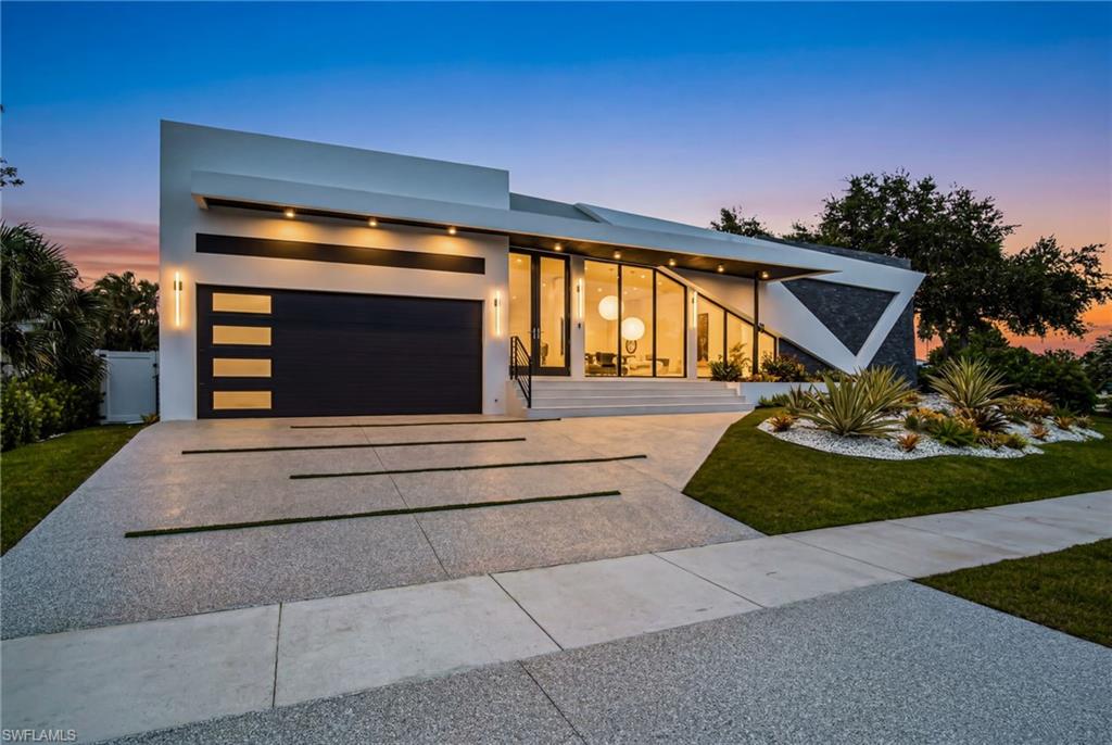 Discover this spectacular modern mid-century estate in the highly desirable Marco Island area. Situated on a private, fully fenced 0.22-acre homesite, this custom-built masterpiece offers over 6,520 total square feet of exceptional living and entertaining space, perfectly blending luxury, contemporary design, and privacy. Crafted with impeccable attention to detail, this stunning residence features 4 spacious bedrooms, 3 full bathrooms, and a chef-inspired gourmet kitchen designed for both everyday living and elegant entertaining. From the impressive 10-foot French entry doors to the expansive impact-resistant windows that flood the home with natural light, every element has been thoughtfully designed to create a seamless connection between indoor and outdoor living. The luxurious primary suite is a true private retreat, offering a spacious walk-in shower, dual vanities, a smart toilet, custom wood cabinetry, and elegant quartz countertops. Throughout the home, you'll find premium finishes including large-format luxury porcelain tile flooring, solid wood interior doors, custom Italian-inspired design elements, and high-end craftsmanship that reflects quality in every detail. Ideally located just minutes from Marco Island's world-famous white-sand beaches, fine dining, shopping, entertainment, and marinas, this exceptional property offers the perfect combination of tranquility, architectural elegance, and modern luxury. Experience the ultimate Marco Island lifestyle in a home where sophistication meets comfort—an extraordinary opportunity to own a truly remarkable residence.