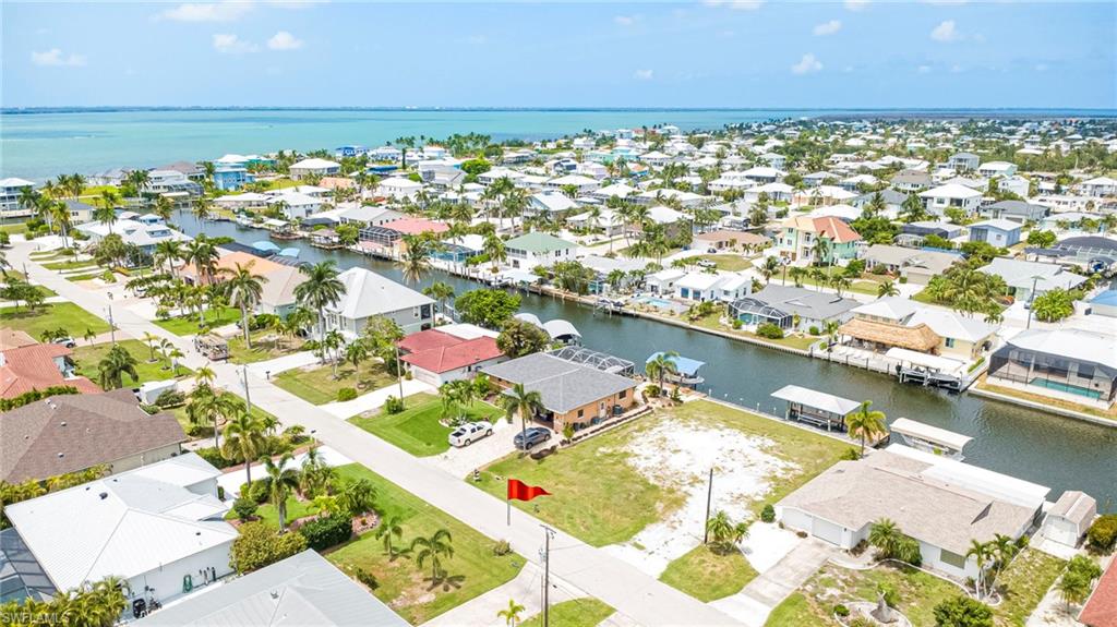 Exceptional waterfront opportunity in the heart of St. James City! This canal-front homesite offers the perfect setting to build your custom island retreat among an area of beautiful upscale waterfront homes.
This property previously featured a home that was impacted by Hurricane Ian and has since been removed, with fill dirt added, creating a blank canvas for your new elevated waterfront residence. A major advantage for buyers to possibly save thousands on impact fees thanks to the prior homesite, making your new construction even more affordable.
The waterfront improvements are already in place, including a new 75-foot cement seawall installed in 2022, a private boat dock with captain's walk, a metal-roofed boat cover, and a hybrid 7,000# boat lift—providing an outstanding foundation for your future waterfront home.
Boaters will love the quick direct Gulf access, allowing you to reach Pine Island Sound, Sanibel, Captiva, North Captiva, Cayo Costa, Boca Grande, waterfront restaurants, pristine beaches, and some of Southwest Florida's best fishing in minutes. Whether you're heading out for a day on the water, island hopping, shelling, dining by boat, or chasing trophy fish, this location puts it all within easy reach.
Enjoy stunning sunsets, tropical surroundings, and the relaxed charm of St. James City. Best of all, you're just minutes from local restaurants, bars, marinas, and entertainment by golf cart, embracing the true island lifestyle that residents love.
With no HOA fees and no deed restrictions, you'll enjoy the freedom and flexibility to create the waterfront lifestyle you've always wanted.
