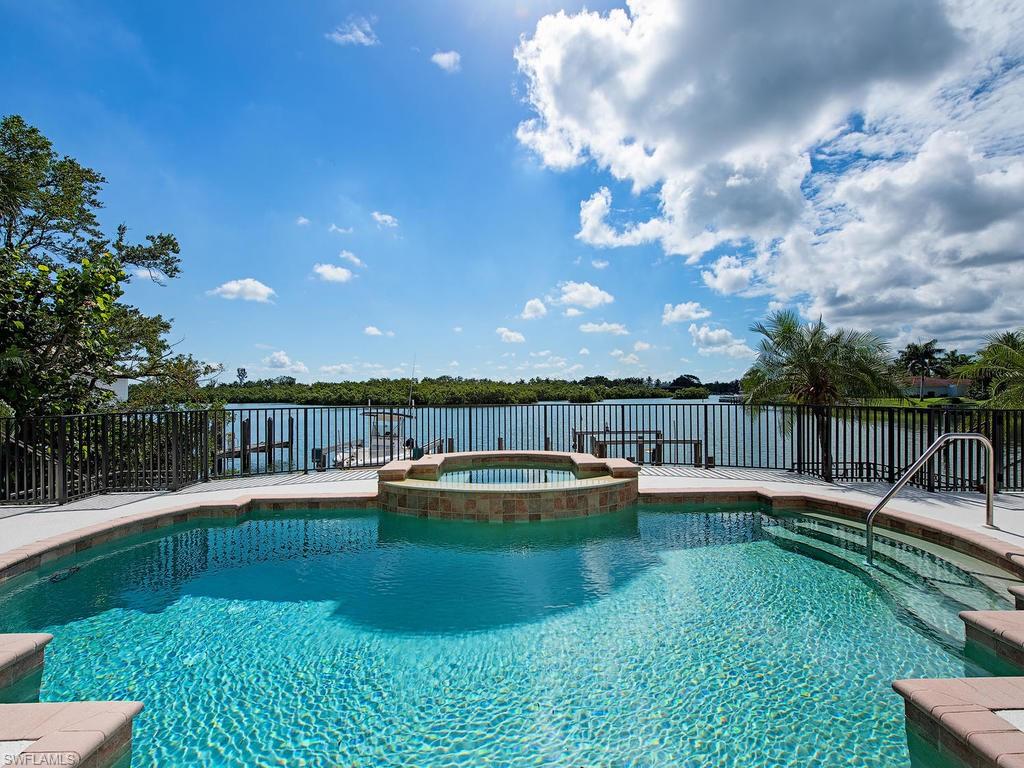H.14590 -Enjoy the easy lifestyle of this home with awe-inspiring views overlooking the wide waters of Champney Bay, and in the distance a protected Mangrove Preserve! French doors across the rear of the home  open out onto the large lanai with sunny pool and spa providing heavenly views from the kitchen, dining area and great room as well as the spacious master bedroom!  The open floor plan and built-in bar make entertaining a breeze! There is also a study on the first floor, and upstairs there are two lovely, large guest bedrooms with en-suite baths. Two boat docks with lifts will accommodate all your water toys, with direct Gulf access out Gordon Pass just a couple minutes away! Walk across the street and right onto the beach via the private beach access deeded to this property, making this a rare opportunity, indeed! This is a very livable property as it is, but the true value is in the land with its exceptional views and location, location, location! Would be an easy rental property or interim home while designing your dream home! The coveted Gordon Drive Beach Estates address gives the owner eligibility for an Associate Membership in the Port Royal Club. Floor plan attached.