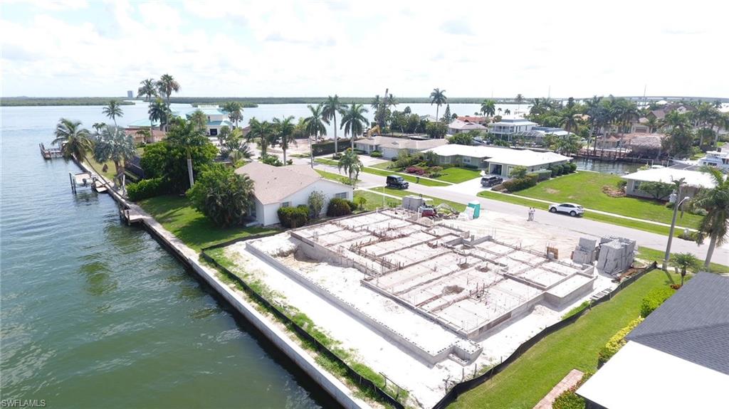 Brand NEW! and ready for YOU early 2023 estimated completion.. Aqua Custom Homes delivers luxury custom homes with a coastal flair that you'll love to live in! This plan features 4 bedrooms including a Primary bedroom and guest suite on the first floor all with private baths. First floor home office finished with custom panels and beamed ceiling and views to the water,!! oversize kitchen with custom cabinets, a hidden pantry- Quartz counter tops, built in Thermadore appliances Great room w/a wall of 10 ft tall sliders and a fabulous disappearing corner transitions you from inside to outside living seamlessly. 13 ft ft ceilings throughout the first floor, featuring customized ceiling details. Stunning custom staircase takes you to the second floor  where you have 2 more spacious guest suites, a loft space, balcony AND BONUS Storage/flex room!! Outdoor living is what its ALL about and this home does not disappoint! Step onto your oversized covered Lanai and look up to see a beamed cypress ceiling! Enjoy the ambiance of your outdoor fireplace and the convenience of a the outdoor kitchen with built in gas grill, under counter fridge and sink, roll down screens and shutters! & SUNSETS!
