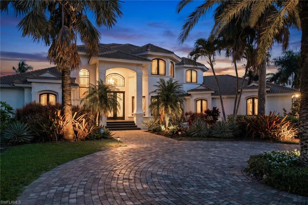 Exceptional in location, lifestyle and character, this spacious Marco Island inland residence offers privacy, comfort and relaxed elegance that defines luxury island living. Tucked away on a quiet cul-de-sac in one of the island's sought-after neighborhoods, the property enjoys beautiful water views, impressive curb appeal, and extraordinary indoor-outdoor living on a beautifully landscaped 0.60-acre homesite. Offering over 4,100 square feet of living space, the expansive floor plan is designed for comfortable everyday living and entertaining. The home features four bedrooms, three full baths, a powder bath, pool bath, generous gathering spaces, and a second-floor loft that opens to an oversized terrace overlooking the pool, tropical landscape and serene water views. Soaring ceilings, abundant natural light, and large windows throughout create an airy atmosphere and a seamless connection to the outdoors. The primary suite serves as a private retreat, complete with a distinctive tongue-and-groove wood ceiling, spacious bath, large walk-in shower, soaking tub and peaceful views of the surrounding landscape. Beyond the interior, the property comes to life. The expansive covered lanai, resort-style pool and spa, cascading water feature, outdoor kitchen pavilion, and multiple outdoor gathering areas create a private backyard retreat designed to enjoy Marco Island's year-round lifestyle. Whether hosting family and friends, dining alfresco, or simply relaxing poolside, the outdoor living spaces offer an exceptional setting for entertaining and everyday enjoyment. The home's grand arrival is enhanced by mature tropical landscaping, a circular driveway, and an extended drive leading to the side-entry three-car garage. Beautiful water views, an oversized second-floor terrace, remarkable privacy, and a resort-inspired atmosphere combine to create a special property in one of Marco Island's desirable residential settings.
