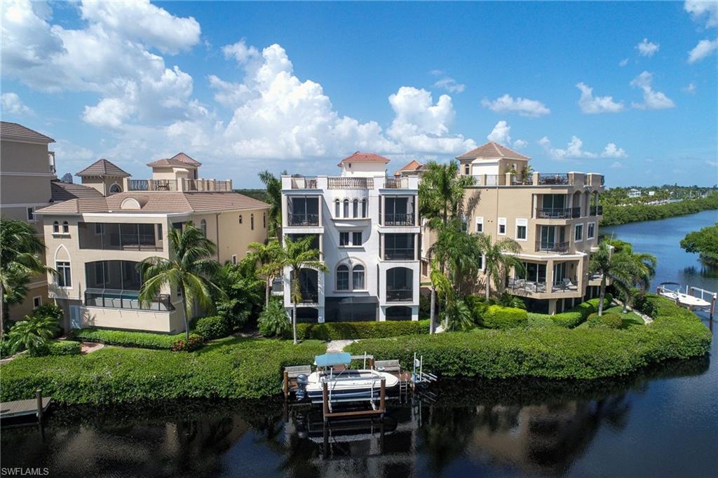 Located within the gated community of Barefoot Bay, this 5 bedroom plus den three story waterfront home includes a boat dock with lift, and offers beautiful bay views with southwestern exposure. Luxurious amenities include, screened pool & spa, monitored security system, private elevator, coffered ceilings, large master suite and bath, central vac., granite countertops, tile and wood throughout. Walk approximately 300 yards to Bonita Beach.  Furniture and furnishings negotiable.