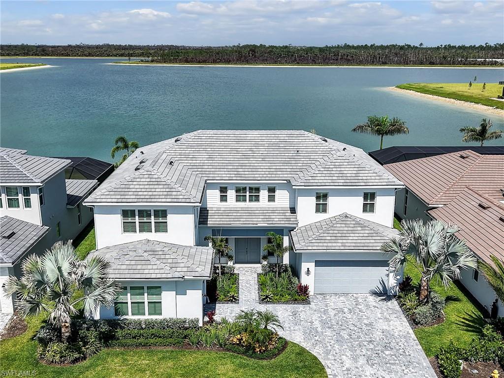 Why wait to build when every luxury upgrade has already been completed? This spectacular 2025 Montego model offers over 5,400 square feet of thoughtfully designed living space showcasing timeless Modern Coastal style that is bright, open, and spacious while feeling warm and inviting. Featuring more than $350,000 in aftermarket upgrades beyond the builder's finishes. Wide plank wood flooring, maple colored cabinetry, soaring ceilings, and designer finishes create an elegant yet comfortable atmosphere throughout. Perfectly positioned on a premium long lake homesite in Flood Zone X, this exceptional residence enjoys unobstructed preserve views, ensuring privacy with no future development behind the home. From the moment you arrive, lush tropical landscaping, tile roof, expansive 3 car garage, and double door entrance create an impressive first impression. A whole house generator and impact windows and doors provides peace of mind, while integrated surround sound, custom lighting, 6 security cameras, 2 AC systems, with 4 thermostats and countless builder and owner upgrades complete this exceptional home. The gourmet kitchen is designed for everyday living and entertaining with an oversized island, abundant storage, two dishwashers, beverage refrigerator, built in wall oven and microwave, drinking water filtration system, under cabinet lighting, designer fixtures, and a large walk in pantry with electrical outlets. Adjacent is an expansive dining area with space for multiple buffets, display cabinetry, bookcases, or even a workspace. The dramatic great room features soaring 20 foot tray ceilings with decorative beams, built in speakers, and expansive impact sliding glass doors that seamlessly blend indoor and outdoor living while showcasing breathtaking long lake and preserve views. The first floor owner's suite is a private retreat with a tray ceiling, oversized dual walk in closets, and a spa inspired bath featuring a freestanding soaking tub, oversized walk in shower, and dual vanities. Also on the first floor are a private guest suite, elegant den with French doors, custom mudroom, and an oversized laundry room with utility sink, cabinetry, storage closet, and elevated washer and dryer. Upstairs, a spacious loft overlooks the main living area while the enormous bonus room offers endless possibilities as a home theater, game room, or children's playroom. Three additional ensuite bedrooms with walk in closets provide exceptional comfort and privacy. Outdoor living rivals a private resort. The 45 foot saltwater pool and spa features a sun shelf, built in bench seating, separate gas and electric heaters, and a pool chiller for year round enjoyment. The extended covered and screened lanai offers a fully equipped outdoor kitchen with grill, sink, refrigerator, ceiling fans, surround sound, and a panoramic screen enclosure framing spectacular long lake and protected preserve views. The seller is also including a one year home warranty.