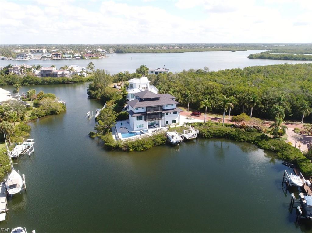 Located on one of the finest waterfront lots in Bayfront Gardens is this newly remodeled Barefoot Beach home.  This just completed 4-story Bayfront Gardens home features an exquisite coastal style. Incredible bayfront setting with panoramic views on a very rare bay lot. This stunning home has five bedrooms and five and a half bathrooms and includes impact windows and roof with the newest codes available. The designer touches are endless and feature oak wood flooring, granite countertops, marble backsplash, Thermador appliances, marble baths and so much more. Light, bright and airy along with being situated in an idyllic cove setting, this home is a must see. The exterior was also redesigned and features two new docks with lifts, composite decking, nautical rope railings, new spa design and pool surface and a beautiful, unique marble driveway and pool deck. 
Additionally, this property sits behind two gates & features a private beach access to the areas finest beach. Note: Year built will be changed after Collier County completes this tax year appraisal since house is completely new including all mechanical components.
