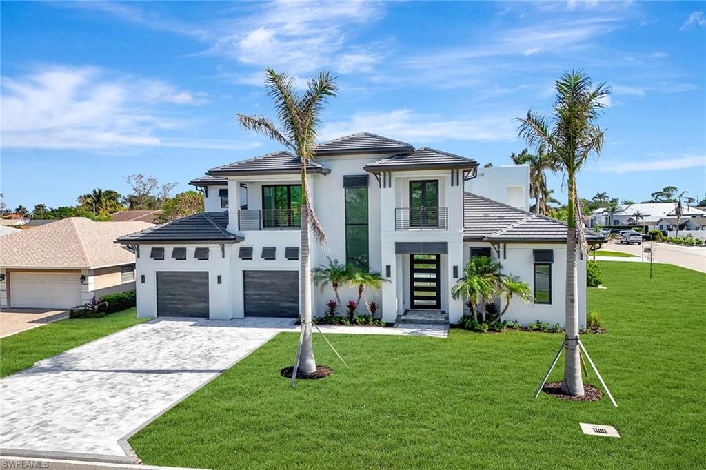 Listed below appraisal value. Appraisal completed March 10, 2025. This exceptional corner lot graces desirable Vanderbilt Drive, positioned between serene Vanderbilt Beach and Delnor Wiggins State Park. Thoughtfully designed, this five-bedroom, five-bath residence embodies a blend of timeless architecture and modern sophistication. The open-concept interiors are bathed in natural light, showcasing luxury finishes throughout. A chef’s delight, the gourmet kitchen features top-of-the-line Thermador appliances, an expansive island and ample space for culinary creativity. The first-floor primary suite offers a private sanctuary with a spa-inspired en-suite bath, while three additional en-suite bedrooms ensure guests and family are accommodated in unrivaled comfort. Designed for convenience and elegance, the home also includes an elevator, a dedicated home office or study, and a second-floor morning kitchen. The outdoor retreat is an entertainer’s dream, boasting a resort-style pool with a water feature and a summer kitchen, ideal for intimate gatherings and grand celebrations. A 2.5-car garage provides generous storage and parking solutions. In North Naples, it provides effortless access to pristine beaches just a mile away, as well as world-class golf, upscale shopping and fine dining. Some rooms have been virtually staged.