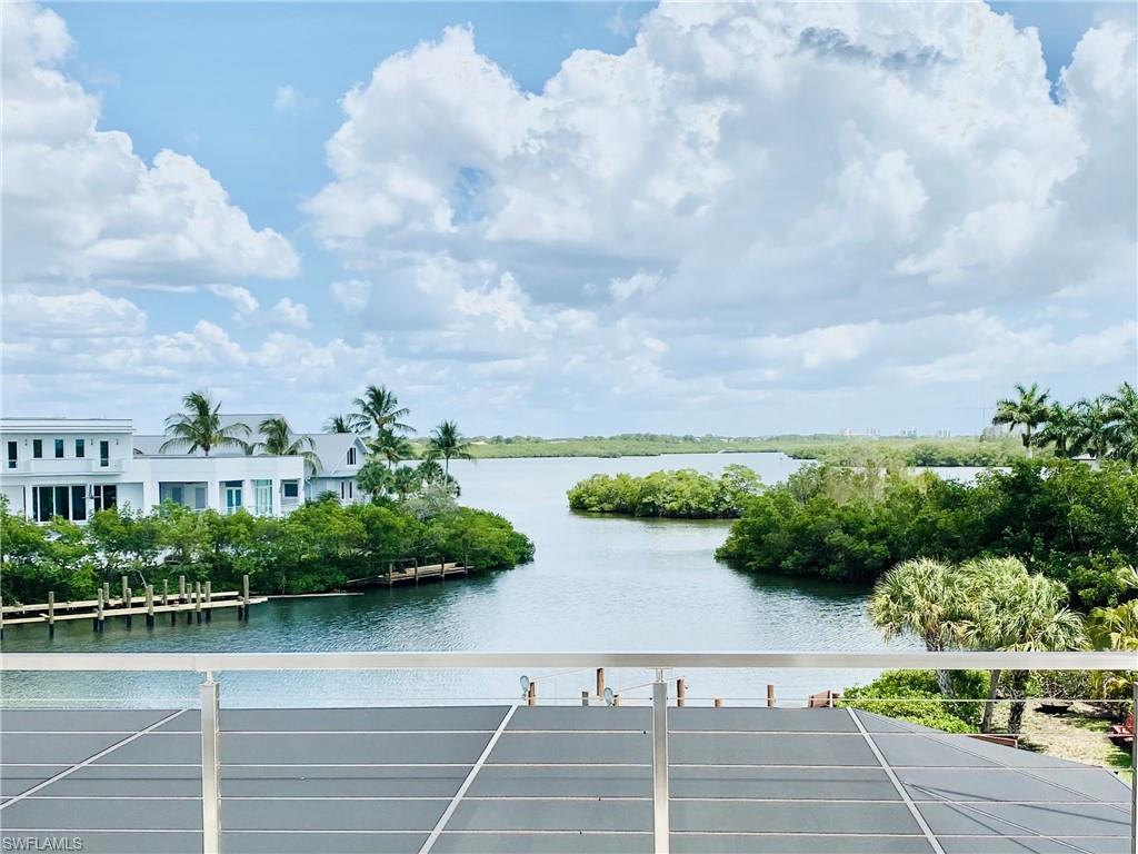 A rare opportunity to own a fully reimagined, like-new waterfront estate in the heart of Barefoot Beach—where southern exposure, long water views, and direct Gulf access converge on an oversized, beautifully landscaped lot designed for exceptional privacy. Offered fully furnished, this residence is truly move-in ready, delivering the appeal of new construction without the delays or disruption. Extensively renovated, the home features impact-resistant doors and windows, along with a redesigned pool and spa deck equipped with updated systems for effortless outdoor enjoyment. The gourmet kitchen serves as a striking focal point, showcasing custom cabinetry, new countertops, and premium appliances, complemented by thoughtfully integrated enhancements including three under-sink beverage refrigerators and a built-in chilled water dispenser. Enormous glass sliders open the second-floor living area to the outdoors, seamlessly blending interior and exterior spaces while framing captivating long water views. Water-facing windows and doors on both the second and third floors further elevate the experience, maximizing coastal vistas from multiple levels of the home. Modern, spa-inspired baths, a spacious laundry room, dedicated storage, and curated finishes throughout complete the interior. Outside, enjoy direct Gulf access from your private boat dock! Prefer sand to sea? The world-famous Barefoot Beach is just steps away. Set within a secure, gated enclave, this estate offers an extraordinary blend of luxury, privacy, and effortless boating and beachside living—the closest thing to brand-new without the headaches of building —and is ready to enjoy today. New roof in 2023. This is your happy place!