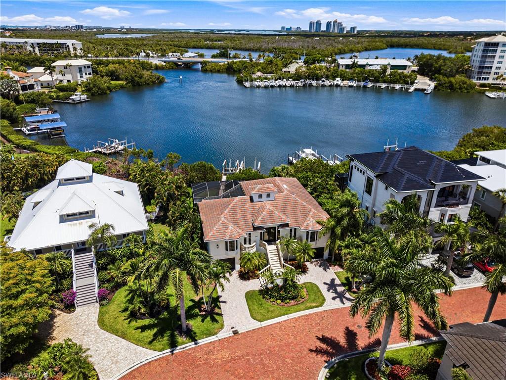One or more photo(s) has been virtually staged, AI generated or rendered.  One or more photo(s) has been virtually staged, AI generated or rendered. Beautiful bayfront residence with direct Gulf-access ideally situated within the exclusive double-gated enclave of Southport on the Bay in North Naples’ highly coveted Barefoot Beach community. A true paradise for boaters and beach lovers alike, this exceptional property offers direct Gulf-access from your private boat dock with dual lifts, just minutes to open water and only a short five-minute walk to the sugar-white sands of Barefoot Beach. This beautifully maintained home features 4 bedrooms + den, 3 bathrooms, a 2019 tile roof, and tile flooring throughout. The spacious kitchen is appointed with light cabinetry and a breakfast bar for casual dining, flowing seamlessly into a bright sitting area surrounded by expansive windows that fill the home with natural light and showcase the stunning bay views. Step outside to the expansive balcony where panoramic bay views create the perfect backdrop for outdoor living and entertaining, overlooking the resort-style pool and spa with a spacious covered lounging area below. The primary suite offers private lanai access through French doors and features an ensuite bath with dual vanities, a glass-enclosed shower, and a separate soaking tub. Optional membership to the exclusive Club at Barefoot Beach provides access to tennis courts, two restaurants, and beachside and poolside food and beverage service. Ideally located near world-class dining, upscale shopping at Mercato and Waterside Shops, Southwest Florida International Airport, and just a short drive to the renowned Fifth Avenue South.