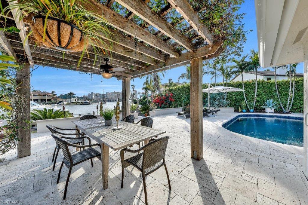H.12663 - Antiipate a short stroll to Seagate beach via private residents sidewalk! Delightful top-to-bottom remodel within this waterfront gem in addition to absolute long, breathtaking SW views of Venetian Bay w/ skyline city views of towering, beachfront condominiums in the background! Modern & natural with an organic flair - the list of NEWER additions & upgrades is a long one: new roof, new bimini shutters, new raised & tray ceilings w/ custom details, top-of-the-line kitchen & appliances, all new baths, all new impact windows & doors, new mahogany front door, new floors, all new SYSTEMS including a zoned Sonos sound system, new closet organizers & new trendy light fixtures! Gather on your new, large 2000 sq ft pool deck enjoying meals under your private, new outdoor pergola w/ new grill area & new evening LED lighting. Hoist your boat to the side of your magnificent 500 sq ft boat dock w/ lift in addition to sparkling water views...an evening must see as well-evening images forthcoming! Surroundng entertainment includes Naples Grande Beach Resort, Waterside Shops, The Village on Venetian Bay plus walk to Seagate Beach & change it up at Park Shore private residents beach!