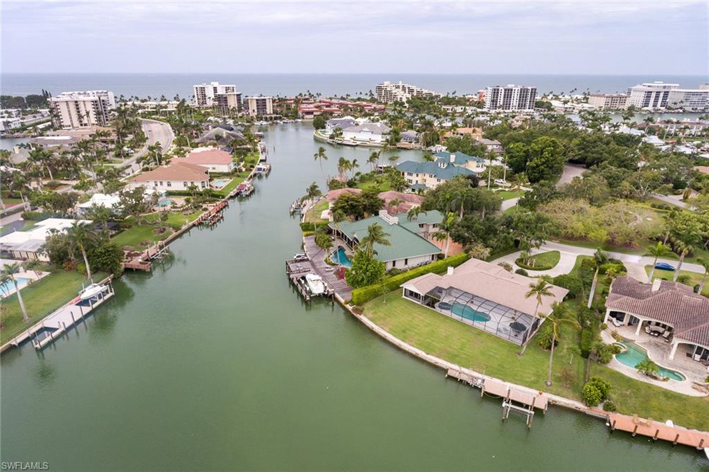 This home is located on one of the most coveted bayfront parcels in the Moorings.  The parcel commands 143 feet on the water with sweeping South Eastern Bay views and affords boaters direct gulf access with no bridges through Doctors Pass.  A City of Naples park is across the street from this home providing a secluded and quiet setting, while owners are eligible for membership in the Moorings Beach Park nearby which offers great amenities for a perfect day at the beach.  The property includes a dock with 10,000-pound lift as well as a hoist davit for a jet ski.  This is a once in a lifetime opportunity to build your dream home on an incredible bayfront parcel.  The property is being sold As-Is, however, the home has been lovingly lived in and maintained and is very livable if you desire to stay in paradise while you design your forever dream home.