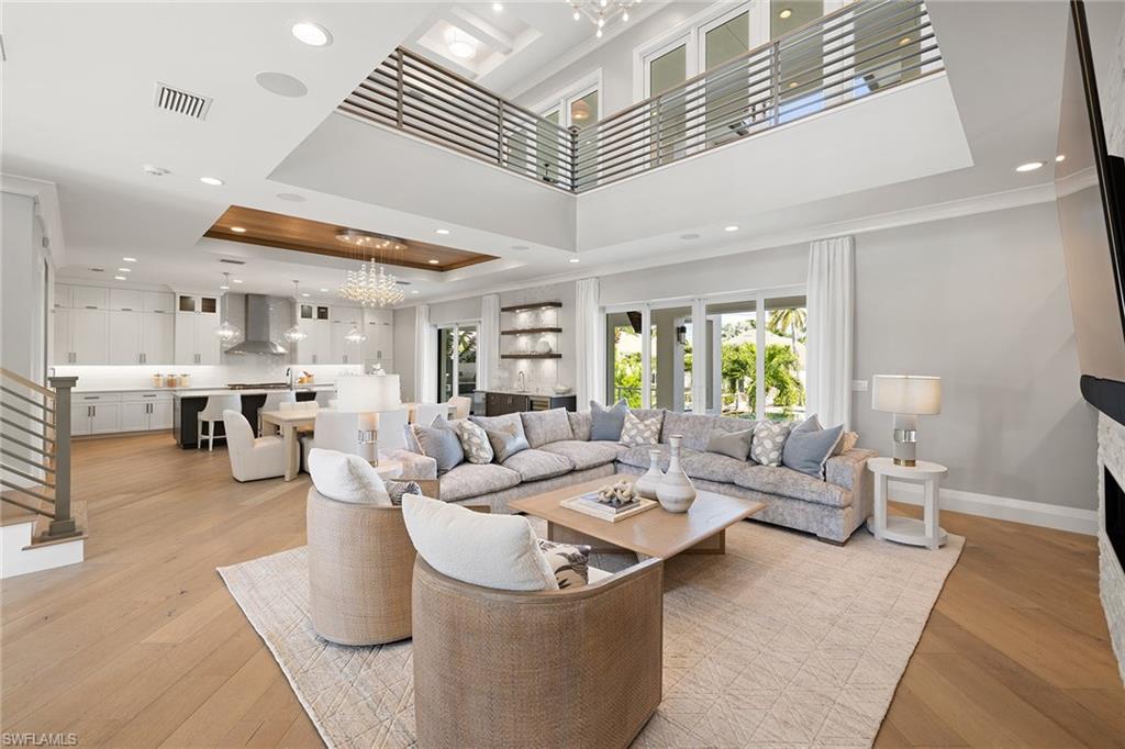 Experience the ultimate in coastal luxury with this newly designed and furnished waterfront masterpiece by Design West, offered furnished and ready for immediate enjoyment. Walls of glass flood the home with natural light, showcasing panoramic water views and exquisite craftsmanship throughout. This four-bedroom, six-bath residence combines modern elegance with relaxed sophistication, featuring impact-resistant Pella doors and windows, soaring ceilings and refined finishes. The open-concept great room impresses with a dramatic stone fireplace and a gourmet kitchen equipped with Wolf appliances, dual dishwashers, a wine refrigerator and walk-in pantry. A serene primary suite, private home office, and elevator access to a loft with three en-suite guest bedrooms complete the thoughtfully designed layout. Designed for entertaining, the expansive outdoor space offers a three-tier pool and spa, fire features and a summer kitchen with pizza oven, all positioned to capture stunning waterfront views. A new boat lift is being added in time for season, complementing the newer seawall, composite dock, and jet ski platform with direct Gulf access and no subdivision restrictions. An air-conditioned eight-car garage and circular driveway make this a car enthusiast’s dream. Just moments from Vanderbilt Beach, the Ritz-Carlton, LaPlaya Beach Club and Wiggins Pass, this exceptional property embodies the best of Southwest Florida coastal living.