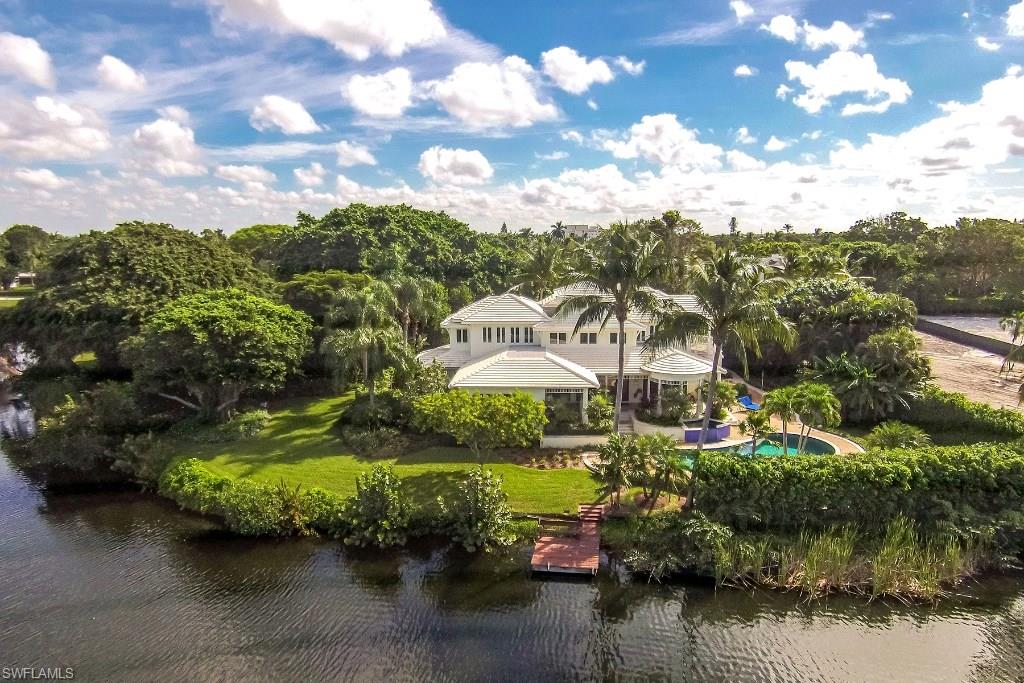 This West Indies-style residence is set on a spectacular 0.69-acre lot and offers 30,013 square feet and 214 feet of lake frontage. Enjoy secluded alley access to an entrance lined with gumbo limbo and banyan trees through a private electronic gate. Designed by Matt Joyner Architects and built by Frontier Custom Homes, the estate features 5,549 square feet of living area, with four bedrooms, a den, a well-appointed kitchen, volume ceilings and a fireplace that serves both the living and dining room. Other amenities include a resort-style pool, three-car air-conditioned garage and much more. Ideal for entertaining, one of the bedrooms is a private guest suite with kitchen facilities and a private entrance. This is a great Naples location just blocks to the Gulf of Mexico, Naples Beach Club Hotel with golf, tennis and spa and all that Old Naples has to offer.