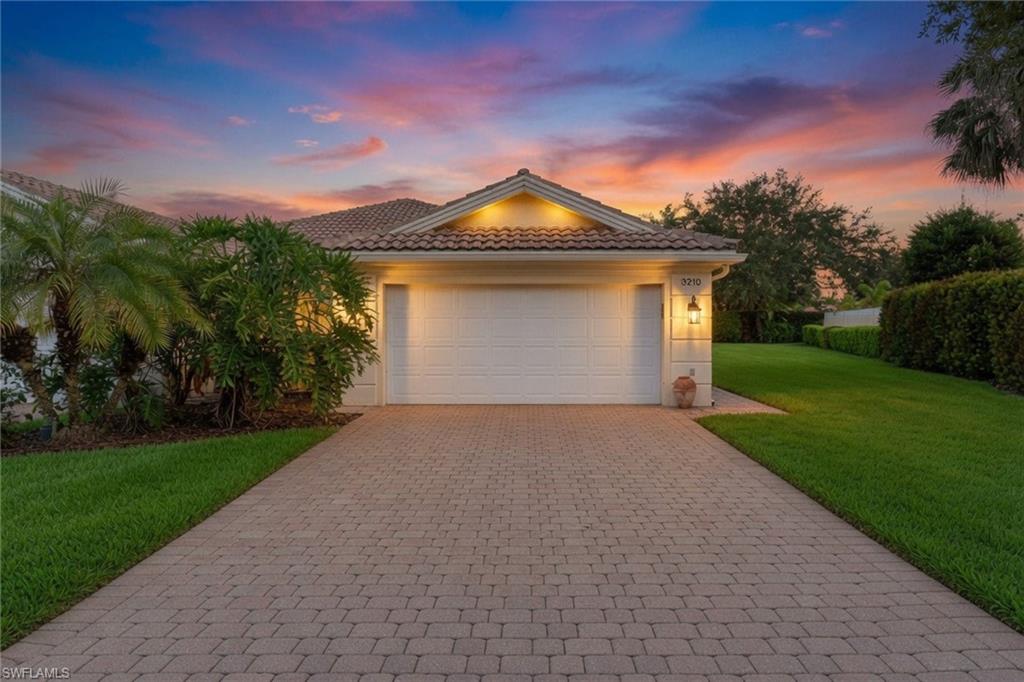 A serene sanctuary, Zen-modern villa in Naples Island Walk. Within the gated enclave of Island Walk, where homes are durable with reinforced poured concrete, this impeccably refreshed villa offers tranquil resort living through a refined, Zen-inspired lens. With its clean modern lines and thoughtful spatial flow, the extended floor plan offers an effortless two-bedroom plus open den and two-bath retreat, ideal for seasonal escapes or year-round serenity. Meticulously maintained and recently refreshed, the home showcases a 2021 roof and air-conditioning system alongside a fully reimagined kitchen that marries function with understated elegance. All appliances have been updated along with a new drinking water filtration system. The central vacuum system adds to ease of living. Luminous 18-inch white tile flows throughout, creating a bright, cohesive canvas that amplifies natural light and visual calm. A striking new glass front door welcomes residents and guests with a sense of openness and contemporary grace. The residence commands an oversized, pie-shaped lot that grants generous privacy. A screened lanai extends living space outdoors, while the expansive private yard invites quiet reflection or gentle recreation. The two-car garage is equipped with a durable epoxy floor and handy cabinets and drawers. Just across the way, a lush community park provides an ever-present backdrop of verdant greenery and shaded respite. Island Walk itself functions as a masterfully planned architectural village. Miles of wide, meandering recreational and biking paths cross picturesque pedestrian bridges, connecting residents to Har-Tru tennis courts, bocce, pickleball, a putting green and a professionally attended fitness center with a robust class schedule. The resort-style pool complex is complete with a dedicated lap pool and anchors the social and wellness core, while the vibrant town center brings together dining, a café, salon, gas station, post office, library and business facilities, all within an accessible, village-like setting. Here, modern design meets resort-scale living in harmony where every detail supports a life of refined tranquility.