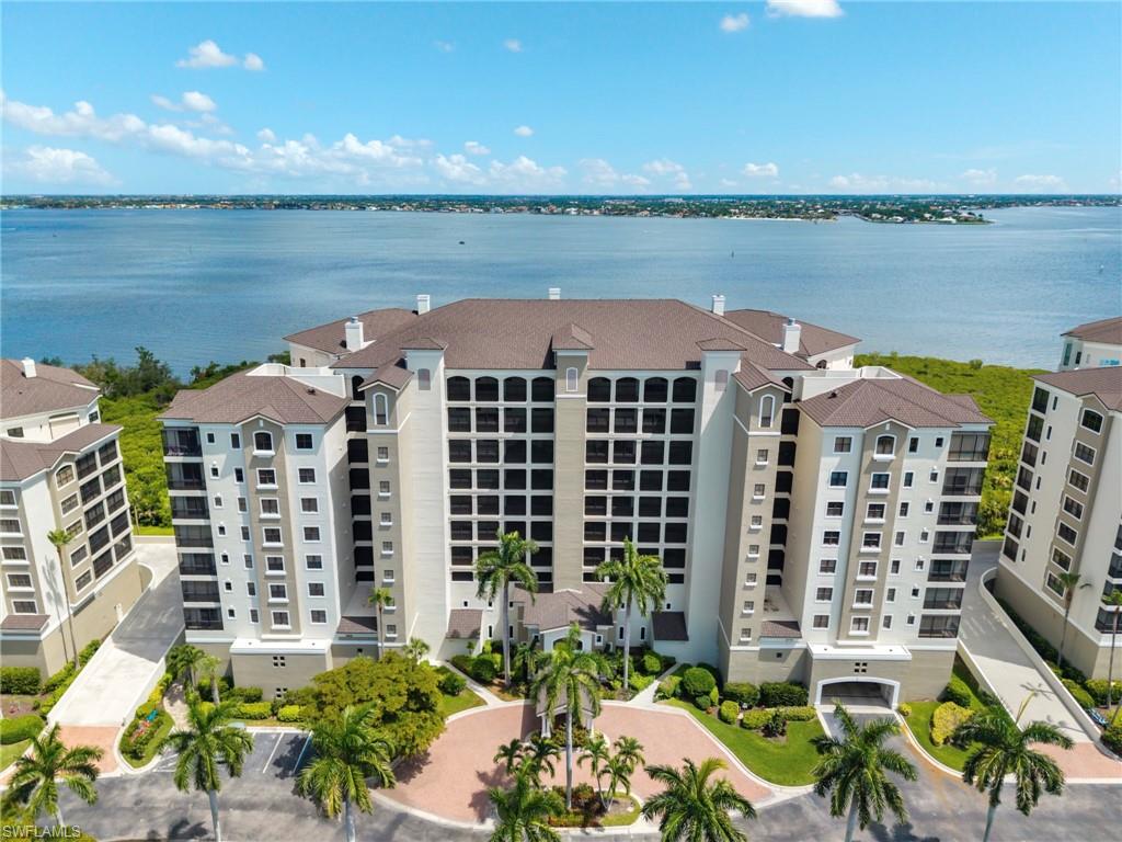 Now is your chance to live in one of the premier waterfront communities in SWFL - Gulf Harbour Yacht & Country Club. Nestled up to the Caloosahatchee River with stunning waterfront views, this rarely available "Castille" floor plan offers 3 Bedroom and 3 baths plus a 2-car garage under the building.  Perched on the 4th floor in Palmas Del Sol, this luxury highrise condo has over 2,800 s/f of living space. Elegance is abound and very evident as you enter through the front door. Open, spacious, and well-lit, the main living area offers wood floors, a custom sweeping archway, crown molding, custom built-in cabinetry, and a wine bar for entertaining your guest. Comfort and style are apparent, neutral earthtone colors plus classic designs make this space a great gathering spot. Here, your focus will always be drawn to the unparallel breathtaking views of the River. Stunning sunsets occur often here! And, relaxing in the large outdoor lanai space has never been easier with designer floor tiles, and electric hurricane shutters for your comfort and protection. The kitchen will sure be an area where the family gathers to create memories and gourmet meals. Large center island with vent hood and cooktop, quartz countertops, 42-inch cabinetry plus an additional sitting area make this a great space in the home. The Primary suite is large and spacious - and has some spectacular views of the River. Oversized walk-in closet with custom built-ins provide great space for your personal belongings. The en-suite master bath has double vanity sinks, makeup counter with mirrors, a soaking tub, and updated walk-in shower. Need to find a great get-a-way spot in the home? The additional two bedroom are split from the Primary. The plantation shutters and carpet flooring make this a comfy retreat when needing some rest. Additionally, there are two updated bathrooms plus spacious laundry room with utility sink.  Newer AC and H2O Tank.  Palmas Del Sol offers a private pool, spa, and clubhouse - exclusively for its residents. Stellar amenities are all optional at Gulf Harbour Yacht & Country Club. Golf and Sports Memberships include an array of activities such as golf, tennis, a state of the art fitness center, full service spa, several restaurants, private beach, and a deep-water marina. You are now HOME!
