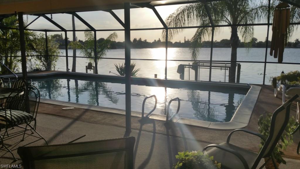 You will just love the sunsets over the lake from this amazing home.  It has a Huge lanai with Huge Pool stunning views of the Freshwater Lake (NO GULF ACCESS), your own concrete dock with boat lift, to enjoy time out on the water.  This home is in a quiet neighborhood with a family friendly atmosphere.  Step inside to see a gorgeous well appointed kitchen with plenty of counter space and an easy flow for preparing meals. And you cant beat the view out the kitchen window.  This home is just shy of 1900 sqft, so you'll have plenty of room to stretch out in.  The bedrooms are split, with the Master on one side, it has a walk in closet, a Master bath with large walk in shower and dual vanities as well as sliders that open up to the lanai.  The guest rooms are on the other side of the house with an updated bath.  One of the guest rooms has sliders to the lanai as well.  And to top things off you have a family room, living room and formal dining area as well.  Come and take a look for yourself, I promise it doesn't disappoint.