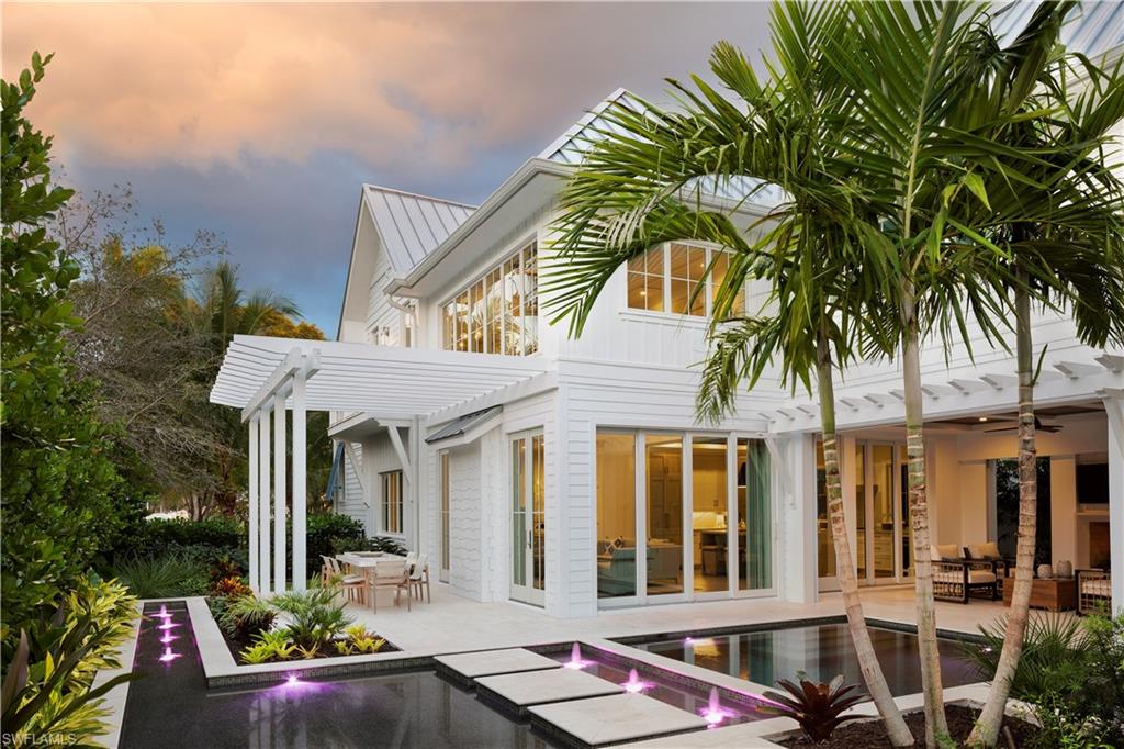 Stock Custom Homes and MHK define Old Naples Lifestyle with a coastal casual design placing a premium on relaxed comfort and luxury. This lavish open floor plan home accommodates 4 en suite bedrooms. Master bedroom is on the main floor with private laundry. Guests will enjoy the attached VIP Cabana suite with private entrance and balcony overlooking the pool below. French oak floors. The kitchen boasts Quartzite waterfall countertops, Sub-Zero, Wolf and Miele  appliances. Dynamic two story living room with intricate ceiling details includes a precast stone fireplace with doors opening to outdoor dining with trellis. Sliders on an adjoining wall open to a shell stone pool deck that features a water wall with a glass mosaic tile background and a stone precast surround that is the focal point of the outdoor living space. Motorized outdoor screens and shutters, a Wolf grill surrounded by porcelain mosaic tile complete the outdoor kitchen. Enjoy the heated salt generated pool and spa and custom landscaping, with an outdoor pool bath. Energy efficient, low maintenance,Andersen impact windows and doors, a 500 gallon LP gas tank, smart home automation, central vac. Three car garage.