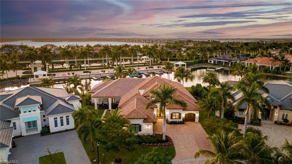 Experience the allure of Salerno's luxurious waterfront lifestyle, where magnificent estates line the shores of Miromar's vast 700-acre lake, offering captivating WATERSIDE panoramas that transform the sky into a canvas of breathtaking sunsets. Crafted by the renowned Harbourside Custom Homes, this former model residence has undergone meticulous enhancements, boasting six bedrooms, an office, den, and bonus room, creating an impressive 5,043 square feet of air-conditioned grandeur. Inside, the home unveils a magnificent open-plan layout, featuring a chef's kitchen, formal and informal dining areas, all adorned with the opulence of rich wood and tile flooring. Upon entering the foyer, you're greeted by sweeping water views, providing a tranquil backdrop for everyday living. The property boasts an expansive outdoor oasis, complete with a pool, spa, fireplace, summer kitchen, and a newly installed boat dock, all complemented by the convenience of a whole-house generator. Modern design seamlessly merges indoor and outdoor spaces, enhanced by refined stone and wood accents. Miromar Lakes Beach and Golf Club offers an array of resort-style amenities, including an award-winning clubhouse, sandy beaches with cabanas, water sports, tennis and pickleball courts, bocce, a fitness center, waterfront dining, an art theater, full-service spa, and premium concierge services. Here, you're invited to luxuriate in unparalleled extravagance, where each moment is infused with sophistication and elegance, set against the backdrop of mesmerizing sunset views.