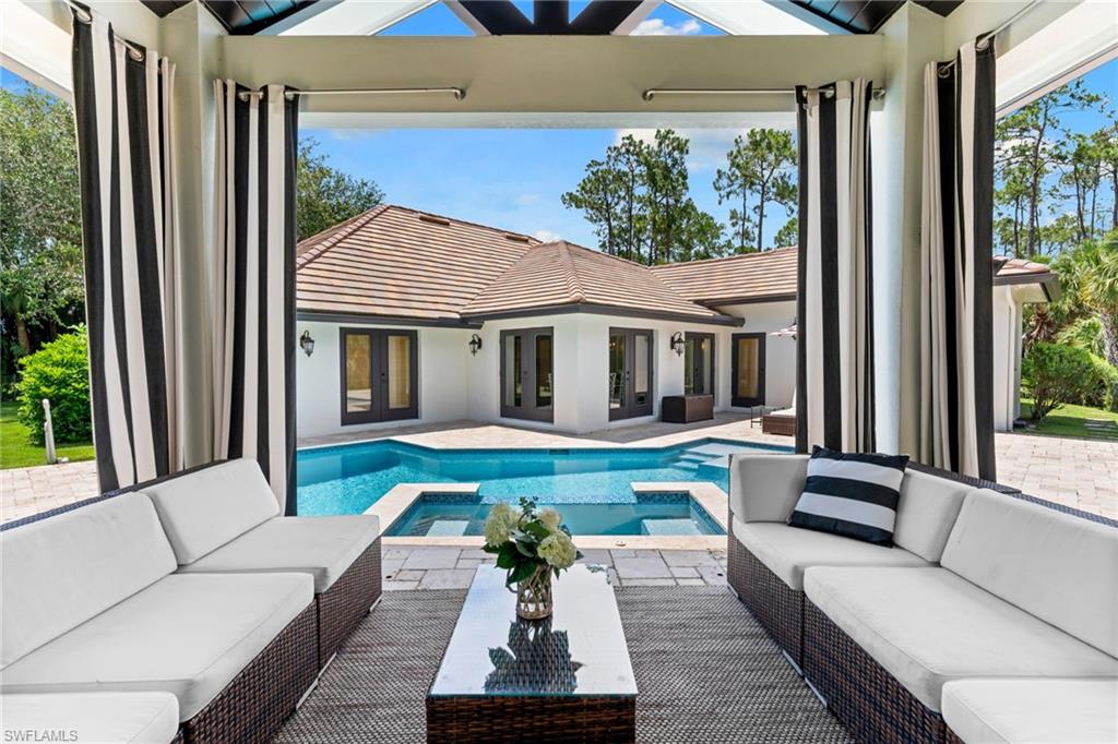 Tucked away on an exceptionally private oversized homesite of more than half an acre with no HOA, this custom estate is a rare sanctuary just four miles from the sugar-white sands of Delnor-Wiggins Pass State Park. Surrounded by lush preserve views with no neighboring homes in sight, this five-bedroom, four-bath residence offers the ultimate blend of luxury, space, and seclusion. The expansive floor plan features soaring ceilings, stunning architectural details, and over 7,000 sq ft of thoughtfully designed indoor/outdoor living spaces. The home features two luxurious primary suites, offering flexibility, and a dedicated home office/den provides the perfect work-from-home retreat. An oversized bonus room offers endless possibilities as a playroom, media room, game room, or additional gathering space. At the heart of the home, the kitchen is designed to impress, featuring a premium GE Monogram appliance package, two dishwashers and an oversized walk-in pantry. Eleganté wide-plank floors flow throughout the home, adding warmth, sophistication, and timeless elegance to every room. The resort-style outdoor setting is truly spectacular. Enjoy complete privacy while lounging beside the sparkling pool and spa, complete with a sun shelf for soaking up the Florida sunshine. The covered poolside cabana elevates outdoor living with its own television, outdoor kitchen, and built-in grill. A spacious three-car garage enhances the home’s exceptional functionality, providing ample room for vehicles, storage, and recreational gear. Rarely does a property offer this level of privacy, acreage, and resort-inspired living in such a prime North Naples location. This is more than a home—it's your own private retreat just minutes from world-class beaches, dining, shopping, and everything that makes Naples one of Southwest Florida's most sought-after destinations.