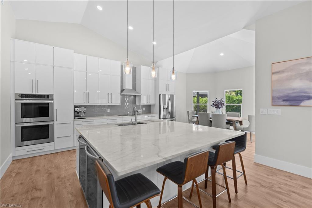 Welcome to 245 Monterey Drive, a beautifully renovated residence where timeless elegance meets modern luxury in the highly sought-after Valley Oak neighborhood of the Vineyards. Perfectly positioned on a private golf course homesite, this exceptional home captures breathtaking sunset views and offers over 2,600 square feet of thoughtfully designed living space with three bedrooms and two beautifully updated baths. Designed for effortless entertaining, the open-concept floor plan centers around an impressive oversized kitchen island, creating the perfect gathering space for family and friends. The chef’s kitchen is appointed with premium LG appliances, a double oven, induction cooktop, beverage refrigerator, and abundant workspace, seamlessly flowing into the spacious living and dining areas. Bluetooth-enabled built-in speakers, smart lighting, and designer finishes elevate everyday living.The luxurious primary and guest baths have been renovated with stunning marble finishes, while updated landscaping and carefully curated design details create a refined, move-in-ready home. Outdoor living is equally impressive with a renovated pool and spa, leathered marble pool deck, 2021 aluminum picture-screen pool enclosure, and expansive lanai overlooking the golf course—an idyllic setting for enjoying Southwest Florida’s spectacular sunsets. Gemstone permanent exterior lighting, sophisticated landscaping, a freshly painted exterior and oversized lantern style lighting adds year-round curb appeal. The stately circular driveway, expansive private homesite, and impact-resistant doors and windows provide both beauty and peace of mind. Recent updates include a metal roof (2022), A/C (2021), pool heater (2020), water heater (2024), and numerous additional improvements that make this home truly move in ready. Located within an A-rated school district, the Vineyards is one of Naples’ most desirable communities, offering an unbeatable central location with convenient access to I-75, world-class dining, shopping, healthcare, and everything Naples has to offer. Luxury, style, and exceptional craftsmanship come together in this remarkable golf course residence.