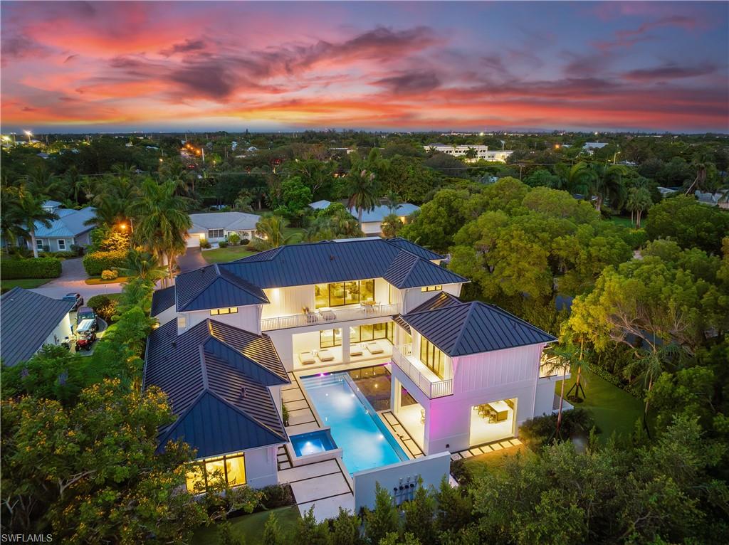 Newly constructed, never lived in and move-in ready, ideally situated on an oversized premium corner lot, this luxurious new-construction residence embodies the spirit of Naples living. Designed by MHK in collaboration with Waterside Builders and Diana Horsley Interiors, the spectacular light-filled six-bedroom + den home flows gracefully from one engaging space to another. Finished to the highest standard, the open floor plan with voluminous ceilings features multiple fireplaces, European oak floors, Ruben Sorhegui tile, quartz counters, elevator, and generator. Chef’s kitchen offers Subzero, Wolf and Miele appliances, large center island and generous butler’s pantry with additional storage and appliances. A full wall of pocketing glass sliding doors leads to spacious outdoor covered living areas, including an outdoor lounge, dining area, summer kitchen, half bath, and heated pool and spa with western exposure. First-floor primary retreat includes substantial dual walk-in closets and a spa-like ensuite bath with separate water closets. Bonus room, wet bar, balcony, laundry and five additional en-suite bedrooms, including a cabana/VIP suite with private entry, provide comfortable accommodations for guests on the second level. In close proximity to 5th Avenue S, Third Street S and sugar sand beaches, this home represents a rare opportunity to enjoy the best Naples has to offer.