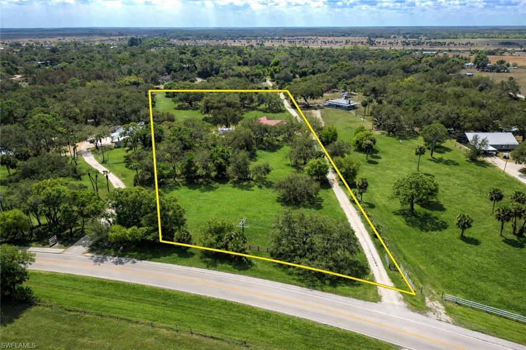 Turnkey country living on over 6 beautiful acres beneath majestic oak trees! This spacious 4-bedroom, 3.5-bathroom home is being sold fully furnished, offering a rare move-in-ready opportunity in the peaceful countryside of Ortona, Florida. Built in 2011 and offering 2,920 square feet under air, the home features a durable metal roof, a thoughtfully designed floor plan, and plenty of space for both everyday living and entertaining.

A welcoming covered front porch leads into a bright and inviting interior with high ceilings, crown molding, and wood-style flooring throughout much of the home. The large main living room flows seamlessly into the dining area and expansive kitchen, creating an open gathering space ideal for family and guests. The kitchen offers abundant cabinetry, generous counter space, a center island, and a breakfast bar overlooking the living area, making it both functional and perfect for entertaining.

The split-bedroom floor plan provides privacy and flexibility. The spacious primary suite offers plenty of room to unwind and includes an ensuite bathroom with dual vanities, a soaking tub, and separate shower, along with a walk-in closet. Three additional bedrooms are well-sized and provide comfortable accommodations for family, guests, or a home office setup.

Outdoor living is just as appealing. A large screened-in back porch overlooks the scenic acreage and offers the perfect place to relax and enjoy Florida’s natural beauty. The property features mature oak trees, open grassy areas, and plenty of room for outdoor recreation, gardening, animals, or additional outbuildings. A detached workshop/garage with a roll-up door provides excellent storage for equipment, tools, or hobbies.

Conveniently located within easy driving distance of LaBelle, Moore Haven, and the Caloosahatchee River, this property offers the perfect balance of privacy and accessibility. Whether you're looking for a full-time residence, seasonal retreat, or private rural getaway, this fully furnished home on 6+ acres delivers space, comfort, and the true charm of country living.