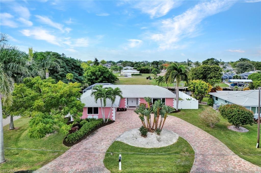 Discover the perfect blend of character and comfort in this beautifully updated 3-bedroom, 2-bath home on a Gulf-access canal. Inside you will be greeted by a spacious Great Room bathed in natural light with a new hurricane-impact picture window (2024). The home’s retro 60s–70s vibe adds personality, while updates ensure modern convenience. The kitchen has sleek finishes and stainless-steel appliances (2023), and the guest bathroom underwent a full remodel in 2023. Durable tile flooring flows throughout, perfect for effortless Florida living. Relax or entertain on the expansive covered lanai overlooking an oversized pool, resurfaced with pebble tech. The fully fenced backyard features black aluminum chair-rail fencing along the canal and new PVC privacy fencing with gates. A great area for your dog and children to play. Recent Upgrades include • New HVAC system (2025) and ductwork (2014) • Impact-resistant windows throughout (2024) • Stainless steel kitchen appliances, washer & dryer (2023) • Complete plumbing re-pipe (2014) • New roof installation (2018) A bonus is the convenience of having an Electric Level 2 Car Charger for your EV or hybrid, a brick paver circular driveway, a side-load garage, and the tranquility of a corner lot on a quiet dead-end street.