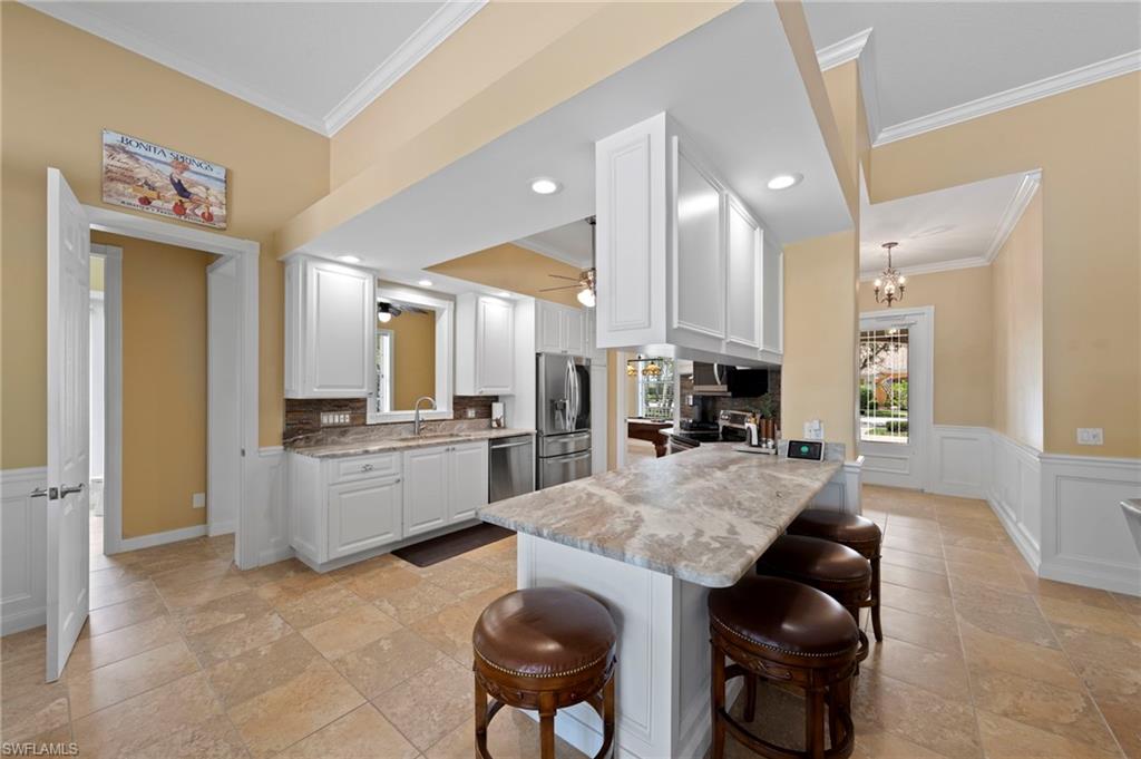 Beautifully upgraded DiVosta-built Carlyle model offering the perfect blend of luxury, comfort, and peace of mind. Meticulously maintained and truly move-in ready, this exceptional home has already completed the renovations today's buyers are looking for. Major updates include a new roof, whole-house generator, fresh exterior paint, expanded driveway, new gutters, epoxy-coated garage floor, central vacuum system, and remote-controlled hurricane shutters with additional accordion shutters for complete storm protection. The stunning chef's kitchen is the heart of the home, featuring leathered quartzite countertops, custom cabinetry, a large center island with additional storage and seating, a 36-inch full-size refrigerator, pull-out drawers, and an impressive oversized custom pantry. Designed with both elegance and functionality in mind, the spacious floor plan offers soaring 12-foot ceilings in the living room, 10-foot ceilings throughout the remainder of the home, abundant natural light, four spacious bedrooms, a dedicated office, and four beautifully renovated bathrooms. Designer finishes include custom wainscoting, crown molding, and tile flooring throughout—there is no carpet. Outdoor living is equally impressive with an expansive 25' x 50' screened lanai featuring a panoramic picture-window screen enclosure that showcases tranquil water views, creating the perfect setting to relax or entertain. Built with DiVosta's renowned poured concrete and reinforced rebar construction, this home offers exceptional strength, durability, and lasting quality. Located in the highly desirable VillageWalk community, residents enjoy an unmatched resort lifestyle with 8 lighted tennis courts, 3 pickleball courts, bocce, resort-style and lap pools, a 24-hour fitness center, on-site restaurant, salon, car wash, gas station, scenic walking and biking paths, butterfly gardens, and abundant native wildlife. Conveniently located just minutes from Bonita Beach, world-class dining and shopping, Southwest Florida International Airport (RSW).