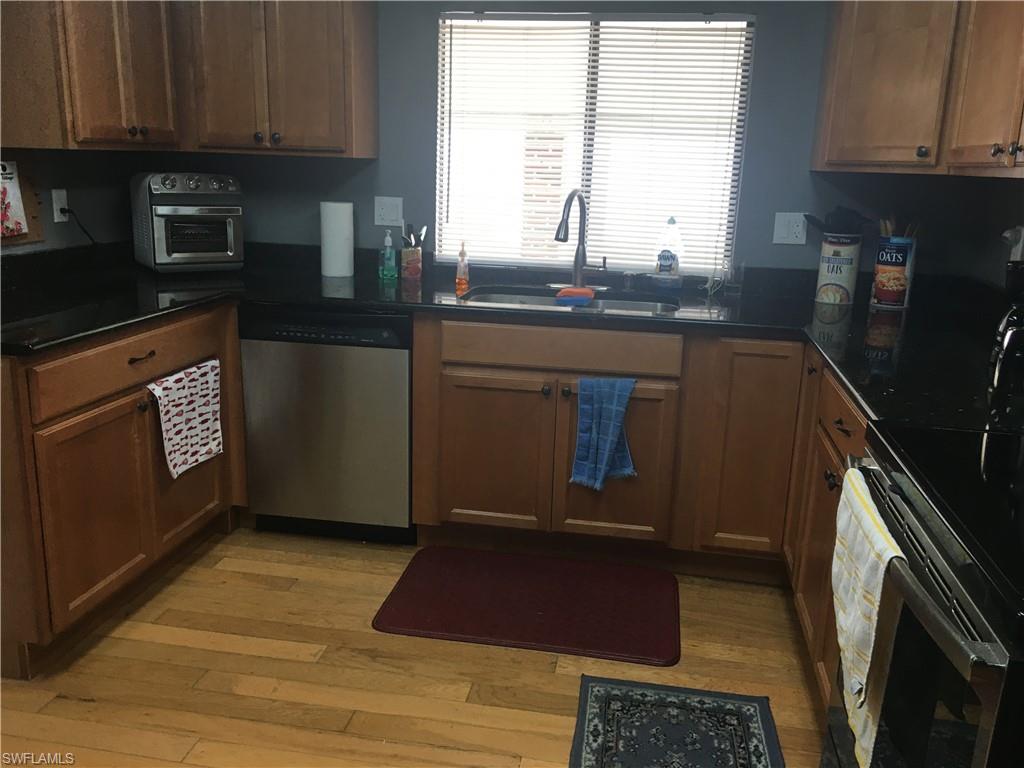 Beautiful OPEN CONCEPT home in very desirable Tamiami Village.   A MUST SEE !! 2 DRIVE WAYS**NO NEIGHBORS BEHIND YOU & VIEW OF CREEK**SCREENED FRONT PORCH** Long Driveway under the carport and side Entrance into home. Home has TONS of storage and closets. UPDATED KITCHEN with Wood Cabinets, Granite Counters, SS Appliances & Pantry. Large Family Room, Dining Room with built in Hutch. Large MBEDROOM with lots of closet space. Guest bath updated, wood cabinet & granite top. Guest bedroom has 2 closets & built in drawers. Outside laundry area has tons of storage and access to workshop area for the men. 2 doors that open to let a golf cart inside. Tamiami Village offers you the opportunity to enjoy three swimming pools, two shuffleboard courts, horseshoes, two billiard rooms, two clubhouses, exercise room, library and a multitude of daily activities. Pet Friendly, Seasonal activities including Bingo, get around the park by bicycle, walking or golf cart. Shell factory is across the street along with other restaurants & home depot close by. Best deal in the park for a large home like this !