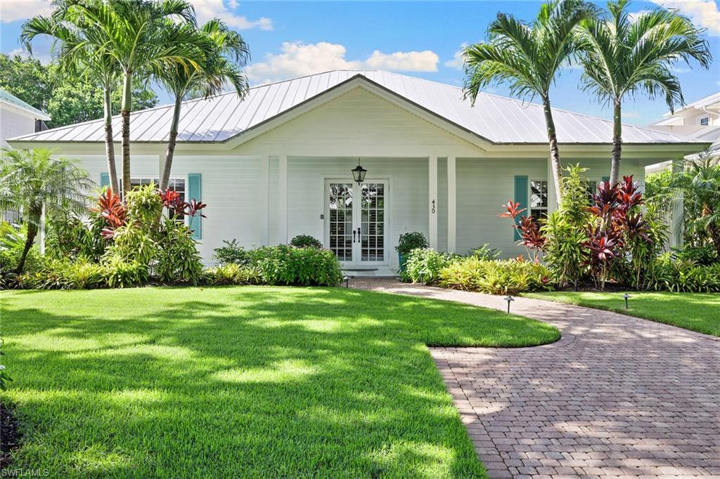 Charming Old Naples cottage style home on beautiful tree-lined 2nd Ave North just four blocks from the beach. A whimsical front porch leads you into the living room with volume ceilings, crown moldings and eight-foot French doors looking into the idyllic backyard. The bright kitchen with a Wolf induction cooktop opens to a generous family/dining area with a cozy fireplace. French doors from the living areas and the primary bedroom lead to the large screened back porch with a beautiful tongue-and-groove cedar ceiling. Lounge on the porch overlooking the enchanting, private backyard with a pool, spa and new stone pool deck. Recent upgrades include new wood plank flooring and paint throughout, custom office built-ins, California closets, Sub-Zero refrigerator, AC, water heater, enlarged guest shower, Encore garage cabinets and finished floor, pool heater, fence and more. The residence sits on a generous .23-acre lot with southern exposure in a desirable flood zone with back alley access to the two-car garage. Plenty of parking on the front and back driveways. Close to the shops and restaurants on 5th Ave S and 3rd St S. This is the perfect Old Naples retreat.