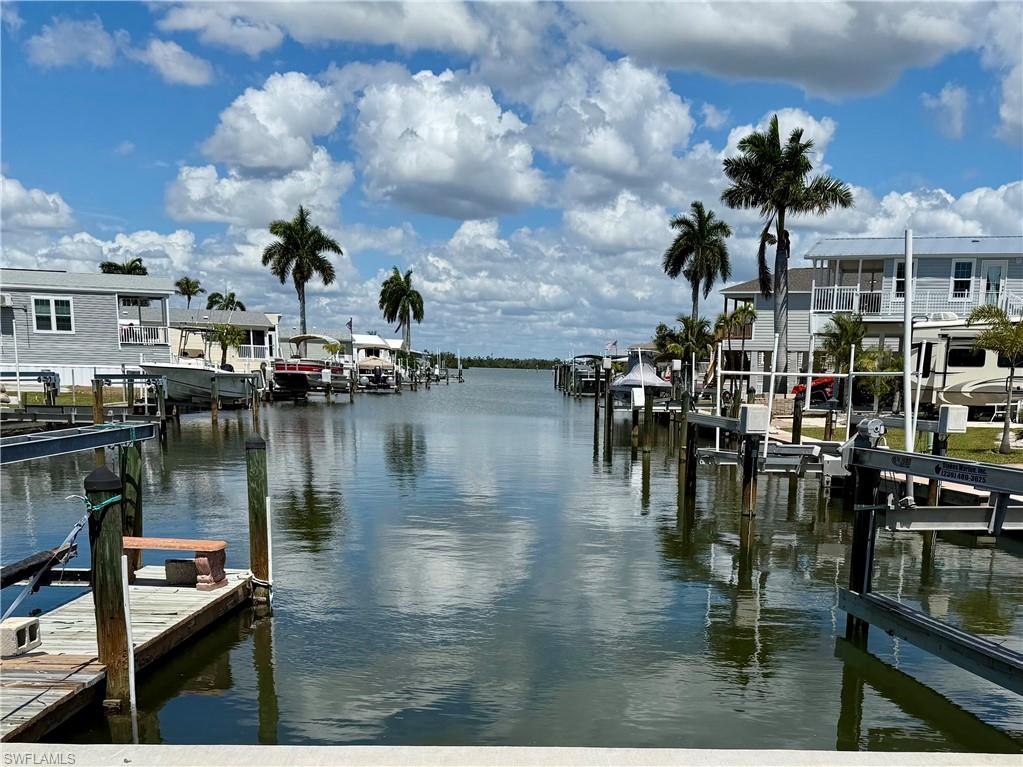 spacious canal lot with a great location which offers a great opportunity to build an exceptional elevated home. This Lot orientation offers a rear facing long canal view minutes from the pristine Estero Bay. There are currently many smart owners who recognize the opportunity to enjoy low fees with amenities in this 55+ community.  Port Carlos Cove is an active lifestyle boating community geared to those who want to live life fishing, boating, exploring the back bays & socializing in a beautifully refurbished clubhouse with amenities. Amenities include: New Community Pool & renovated clubhouse, Pickle Ball, shuffleboard, Bocci, and an active social club. LOW HOA FEES-yes--$200 PER MONTH includes: Water, sewer, irrigation, seawall, landscape, pool maintenance. A two minute commute to the unparalleled, pristine Estero Bay awaits. If you own an RV, you will be able to keep it on your parcel while you design your home!  Conveniently located very close to great restaurants and on a canal that is dredged in perpetuity by Lee County! Zoning options include stilt build or Modular style home. Please note that the modular home shown as depicted are presented on this site are for suggestion purposes only. Dramatic Miami style design plans are available with several flexible buyer options if you are interested. Lot will provide a spacious 2/3 bed/2 bath home + ample room for a design with  back sitting area overlooking the canal and will provide ample parking & easy placement of stair access.  Port Carlos Cove resides in Lee county jurisdiction; no impact from Ft. Myers beach restrictions! Also, the reinforced bulkhead on site is well maintained. As an owner, you will enjoy an easy cruise to explore & fish the back waters of the renown ESTERO BAY, PLUS DIRECT GULF ACCESS WITH NO BRIDGES! Port Carlos is perfect community to grant dramatic views where you will see Bald Eagles, Osprey, manatee, spotted eagle rays, Dolphins, fish jumping & more. Port Carlos Cove community is a very unique & rare property. It is defined as: 45 acres surrounded by an environmental preserve with its own canals and over a mile of seawall. Where else can $200 HOA a month can you own a property in such an area with its own boat ramp and dock, clubhouse with Pool, Shuffleboard & pickle ball courts, "back 40 acreage" spacious storage area for boat, Utility trailer, RV or extra car storage? Also, Port's Compound area: free lawn and landscape service, and trash disposal, water and sewer. lot INCLUDES a large ADDITIONAL protected area for parking and storage+ on this 16-acre site assigned to each resident for your trailer/camper (INCLUDED with your Deed).. Port Carlos Cove 55+active lifestyle, co-op community allows limited rentals (30 days-6x per year). INCREDIBLE- WALK to Ft. Myers Beach & Margaritaville, Key West Express terminal, & 2 Caribbean feel restaurants; plus a pirate ship! a five min drive offers Endless fun times on Ft Myers Beach!  Your boat awaits!