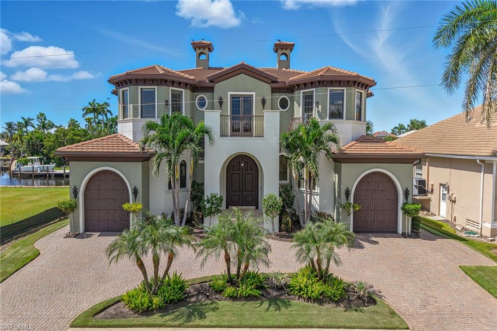 This stunning waterfront residence offers direct Gulf access, three private balconies, 80 feet of water frontage, and two spacious primary suites, creating an exceptional opportunity for luxurious coastal living. Designed with comfort and style in mind, the two-story home features five bedrooms plus a den, five-and-a-half baths and two individual garages, each with one-car parking, blending thoughtful design with modern finishes throughout. The exterior is highlighted by a 2022 roof, impact-resistant doors and windows, a grand mahogany double door entry and a fenced backyard. Outdoor living is enhanced with a pool and spa, outdoor shower, rough-in for an outdoor kitchen and wiring for outdoor speakers above the pool. A private dock provides quick Gulf access and comes equipped with a boat lift, a three-jet ski lift platform, and rip rap seawall reinforcement. Inside, the tray ceilings, recessed lighting, crown molding, modern ceiling fans and white plantation shutters create a refined backdrop. The open floor plan includes tile flooring on the first level, wood flooring upstairs, and custom closets in all bedrooms. The chef’s kitchen showcases transom windows above a glass slider opening to the pool, a tile backsplash, a large five-seater island with glass pendant lighting, a walk-in pantry, and stainless steel appliances, including a five-burner gas cooktop. The great room impresses with a coffered ceiling, a floor-to-ceiling arched window, a built-in entertainment center, a gas fireplace, and transom windows above a double glass door opening to the pool. A second-floor loft with a nearby wet bar featuring a built-in wine cooler and two built-in beverage refrigerators offers additional entertaining space. The first-floor primary suite features two sliders to the pool area, dual walk-in closets and a spa-inspired bath with dual vanities, a walk-in shower with a frameless glass enclosure and a jetted tub. Upstairs, a second primary suite enjoys water views, a private balcony and a luxurious ensuite bath. Three additional guest bedrooms are generously appointed, two with private balconies and en-suite baths, while the third has a nearby bath. A laundry room with a full-size washer and dryer and a utility sink adds convenience. Just minutes from Marco Island’s pristine beaches, upscale shopping, fine dining, golf courses and attractions, this residence offers the ideal blend of coastal luxury and an active waterfront lifestyle. Whether boating, kayaking, paddleboarding, or simply relaxing poolside, this property embodies the best of island living with effortless gulf access. This residence conveys with a transferable flood policy, providing seamless protection and convenience for the new owner.