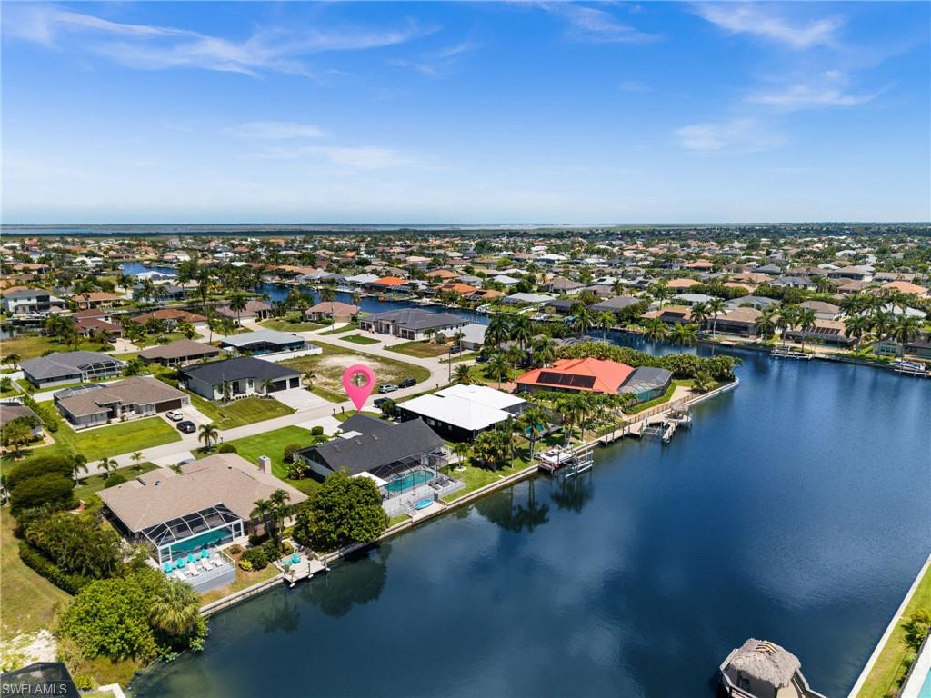 A Boater's Dream. Inviting. Freshly upgraded. Positioned on an extra-wide direct Gulf access canal, this extensively remodeled waterfront residence captures the essence of effortless coastal living with a clean, refined design and immediate boating convenience; only one bridge to southern Spreader Canal, open water ahead.

Offering 3 bedrooms plus a dedicated DEN/office and 2 spacious baths, this light and bright home opens into an  expansive living space defined by distinctive wood-paneled ceilings and skylights that fill the interiors with natural light.  The entire residence has been thoughtfully upgraded, including new flooring, upgraded baths boasting beautiful Italian porcelain backsplash, modern lighting, fresh interior & exterior paint, a newer roof, new soffits and gutters and an extended lanai boasting lots of space. Further upgrades include a new HVAC & water heater, new trim, new doors as well as a very nice sliding glass door in front of the office.

The transition to outdoor living is seamless. An extended screened lanai frames wide water views, where a heated pool and spa, outdoor shower, and private dock invite a true Florida lifestyle; boating, entertaining, or quiet sunset evenings overlooking the intersecting canal. The concrete seawall and direct Gulf access position this property as an exceptional choice for passionate boaters.

The kitchen is both functional and visually striking, featuring waterfall granite countertops, stainless steel appliances, and a breakfast bar that connects effortlessly to the main living and dining areas. An indoor wet bar and billiards space add a layer of relaxed luxury, ideal for hosting and everyday enjoyment.

The primary suite is a private retreat with tranquil garden views, dual vanities, a walk-in shower, and a soaking tub designed for unwinding. Two additional guest bedrooms are thoughtfully positioned on the opposite side of the home, offering privacy and comfort for family or guests. The den, converted from a former hammock room, serves perfectly as a home office or flexible living space.

Additional features include high-speed internet, cable TV, air conditioning, full-size washer and dryer, and a well-appointed outdoor setting with grill, private yard, and multiple areas to relax or entertain. 

Whether envisioned as a primary residence, seasonal escape, or income-producing investment, this property delivers a rare combination of full-scale renovation, direct Gulf access, and lifestyle-driven amenities in one of Cape Coral’s most desirable waterfront settings - and a transferable flood insurance adds to your peace of mind.