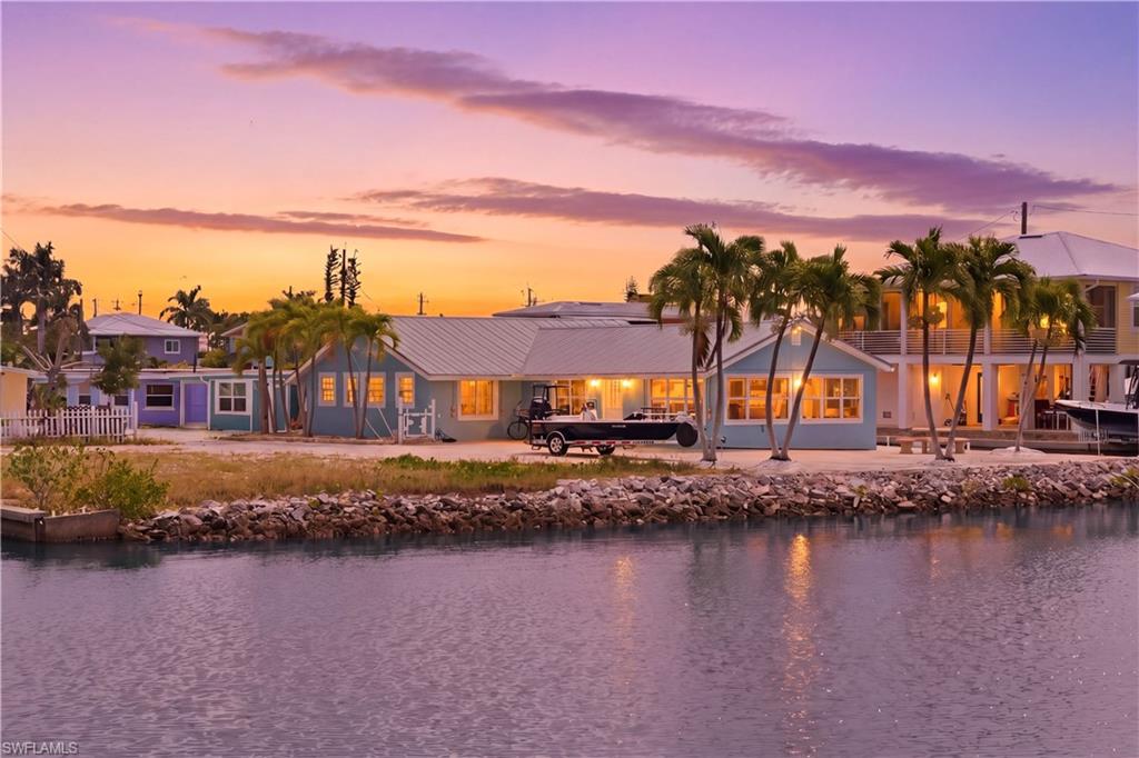WEEKLY, MONTHLY, OR SEASONAL RENTAL AVAILABLE – 7-NIGHT MINIMUM STAY! Escape to paradise in this beautifully remodeled, turnkey furnished waterfront home located on a coveted peninsula in the charming island community of Matlacha. Surrounded by sparkling bay waters and breathtaking sunsets, this exceptional property offers 2 bedrooms plus a den and 2 full bathrooms, providing plenty of space for vacationers and seasonal residents alike. Thoughtfully renovated from top to bottom, the home features soaring cathedral ceilings, abundant natural light, luxury vinyl plank flooring throughout, and stylish designer lighting. The stunning kitchen boasts 42" cabinetry, Sea Glass quartz countertops, an oversized apron-front sink, and modern finishes. Spa-inspired bathrooms feature natural pebble shower floors, creating a relaxing coastal retreat. The flexible floor plan is ideal for guest accommodations, home offices, or extra living space. Large closets provide ample storage, while the oversized laundry/mud room adds convenience and versatility. Step outside and enjoy panoramic waterfront views where dolphins are often seen playing in the bay. Boating enthusiasts will appreciate direct Gulf access, a private boat lift, and plenty of dock space. Whether you're fishing, kayaking, boating, or simply relaxing by the water, this property offers the ultimate island lifestyle. Outdoor living spaces are perfect for entertaining, dining al fresco, or unwinding while taking in unforgettable sunsets and moonrises. Located just minutes from Matlacha's colorful art galleries, waterfront restaurants, unique boutiques, and local attractions, you'll enjoy the perfect blend of island charm and modern convenience. Offered turnkey furnished and fully equipped. Available for weekly rentals (7-night minimum), monthly stays, or seasonal rentals. Rental rates and availability vary by season. Come experience the very best of waterfront living in Matlacha!