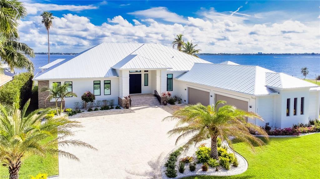 This is your chance to own a one-of-a-kind custom Cape Coral Riverfront Estate sitting on one of the largest single family parcels (¾ acre) in town. Completed in February 2021, this home is built on 59 concrete 10x10 inch 8-10 ton pilings. This contemporary Estate offers an unparalleled 4,781sqft of ground floor living area and a massive 12,064sqft total area incl 1,516sqft garage with min. 5 car and/or boat capacity. Enter through the massive steel doors into the 14ft ceiling Foyer and immediately take in the expansive river views highlighted by 80 feet of impact resistant 10ft high sliders throughout the living areas.  New 120ft seawall 2019, composite boat dock/lifts Oct 2020 w/ large sundeck & versatile platform lift that can accommodate 2 jetskis or boat/kayaks. Oversize 38x15 saltwater lappool w/SPA & sunshelf. Custom cabinets w/ quartz counters throughout the home. Spectacular master suite with luxurious in/outdoor showers, soaking tub & sauna. Two additional suites w/ private baths, riverviews & lanai/pool access. 1800sqft lanai with full outdoor kitchen, TV hook-ups & Kevlar storm shutters. Large lot & layout offers possible addition of extra living area/guest building