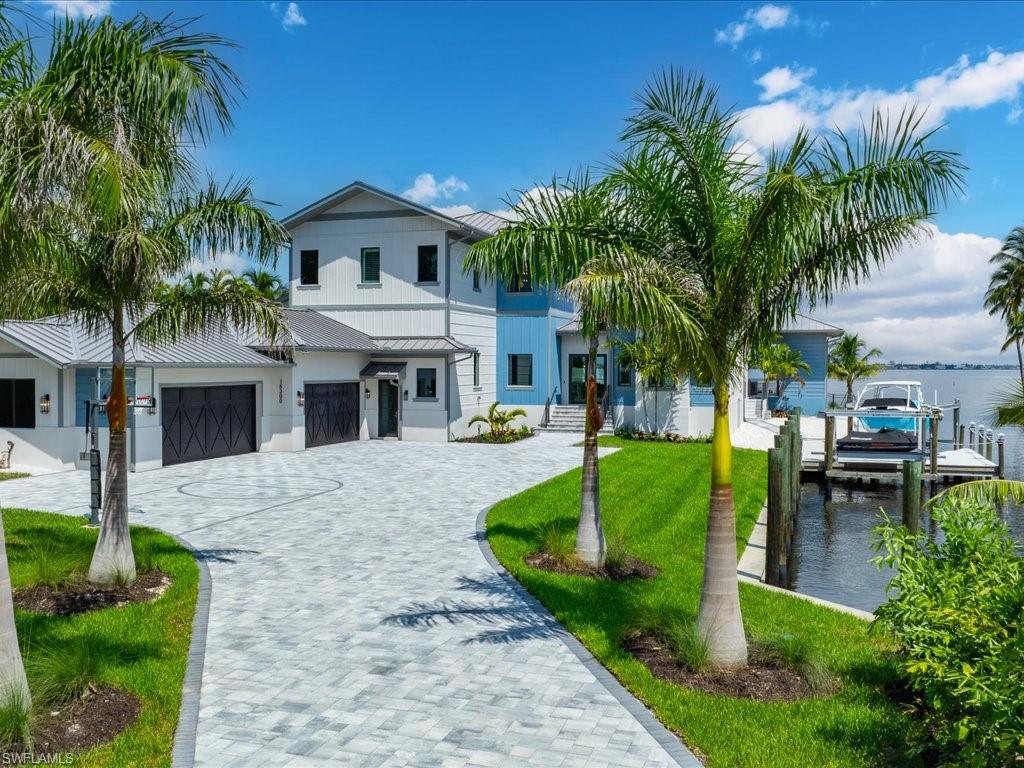 This exceptional residence is being offered fully furnished, presenting a rare opportunity to move in and immediately enjoy a luxurious waterfront lifestyle that blends modern elegance with serene coastal living. Newly constructed and custom-designed, this masterpiece is perfectly situated on an expansive riverfront lot, offering panoramic views, direct Gulf access, and exceptional privacy. Surrounded by lush tropical landscaping, the home’s thoughtful layout ensures peaceful seclusion—ideal for those seeking a quiet, refined retreat.
From the moment you enter the light-filled foyer, you’re welcomed by soaring ceilings, walls of glass, and a spacious open layout that effortlessly blends indoor and outdoor living. Elegant neutral tones, exposed wood beams, and rich wood-look flooring create a warm sophisticated ambiance throughout.
The heart of the home is a stunning great room, ideal for both relaxed evenings and entertaining. The chef’s kitchen impresses with custom Bespoke cabinetry, premium appliances, and a spacious island for effortless dining and gathering. Retreat to the luxurious primary suite, where floor-to-ceiling windows invite in stunning sunset views over the water. The spa-like en-suite bath offers a serene escape with a deep soaking tub, walk-in shower, designer finishes, and a spacious custom closet. Enjoy flexible living with thoughtfully designed bonus spaces, including a private den featuring a cozy window bench with serene views—ideal for a home office or quiet reading nook. Upstairs, a spacious game and theater room offers the perfect setting for entertainment and laid-back relaxation. This home is equipped with integrated smart home speakers throughout, offering seamless audio for music, entertainment, and voice control. Whether you're hosting guests or enjoying a quiet evening, enjoy effortless connectivity and immersive sound at your command.Step into your private waterfront paradise, featuring a resort-style pool, a fully equipped outdoor kitchen, and an expansive patio perfect for relaxing or entertaining under the stars. A dedicated canal slip accommodates a range of boat sizes, offering seamless access to the Gulf of Mexico. From the observation deck, enjoy front-row views of dolphins, manatees, and breathtaking sunsets.  This home embodies the ultimate waterfront lifestyle, featuring a private boat lift, jet ski lift, and a custom fishing pier—perfect for peaceful fishing and enjoying breathtaking sunsets over the water.Additional highlights include an oversized 4-car garage with ample storage, brand-new elevated 22KW whole-house generator with automatic transfer switch, and a prime location. For added convenience and future accessibility, the home has already been prepped for a brand-new elevator—whenever you're ready. This is more than a home—it's a lifestyle.