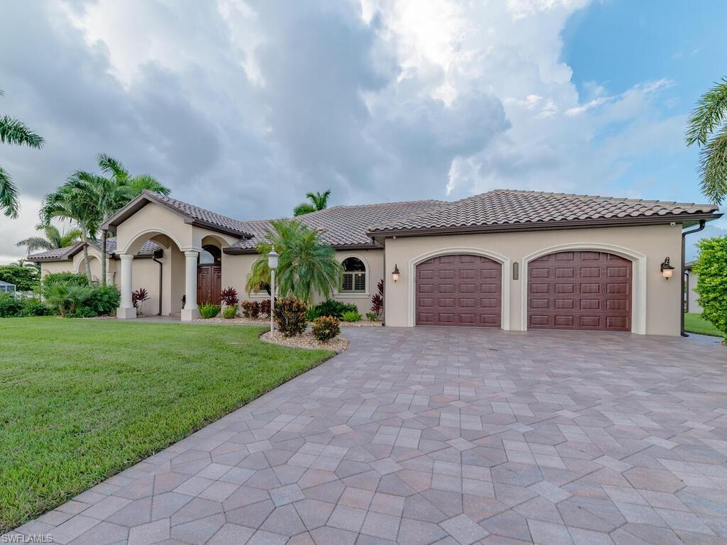 Luxurious sailboat access home on oversized corner lot, overlooking intersecting canals with 265 ft. of waterfront. Every detail was carefully selected and quality crafted. Highlights include a home theater with bi-level seating and 95 in. curved HDTV, pre-wired high end sound throughout, two air conditioning system and a 5 ton mini split ceiling system for cooling and heating with individual control over the temperature in multiple rooms, custom entrance door, crown molding throughout, 10ft. walls, trey ceiling, granite counters and sills, walk-in pantry, porcelan tile, solid maple cabinetry and custom built-ins, designer lighting, custom vanities, two fireplaces, gas heated pebble tech pool, 8 person spa with rock waterfall, outside kitchen with built in grill and stainless steel appliances, 1200 sq. ft. dock with tiki hut, 16,000 lb. lift with canopy, tiled throughout 2 car garage with custom cabinets. Just replaced the left side of the Seawall! It's hard to list all the indoor and outdoor features of this stunning home. Schedule a tour today!