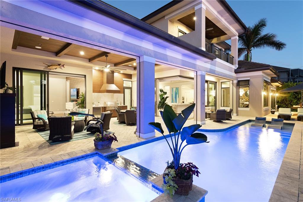 Featured in Gulfshore Life Home magazine, this home spared no expense! This custom-built & designed home was professionally decorated & designed by Leili Design Studios. Foyer has 25' ceiling & custom chandelier. Great room has disappearing edge custom sliding glass doors & intersecting waterway views! Open concept home has wood-look porcelain tile floors. 25' ceilings, custom 3-dimensional media wall, wet bar & wine cooler. Kitchen has Wolf appliances, gas stove & quartzite counters. Master suite opens to outdoor lanai & fireplace, custom lighting & 3-dimensional walnut media wall. Master bath has huge shower, chandelier, dual walnut vanities with leathered marble counters. Upper level has 2 bedroom suites, media room, wet bar, water views! Outdoor living area covers rear of home. Outdoor fireplace, built in grill, quartzite counters, full length saltwater pool & spa. In wall screens, hurricane shutters & disappearing edge doors bring the outdoors in! The huge dock has 2 boat lifts & Jet Ski lifts, each decked over to create a seamless drop-down lift made of composite graphite. 3-car garage with custom epoxy garage floor, suspended storage racks & bike racks! Being sold furnished!