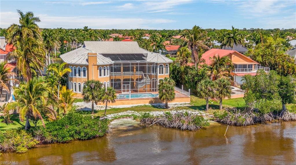 Welcome to an extraordinary, one-of-a-kind estate nestled within the exclusive gated community of Buttonwood Harbor. Perfectly positioned on a rare half acre lot offering a serene pond view in the front and breathtaking frontage along the Caloosahatchee River in the rear, this remarkable residence delivers unmatched elegance, privacy, and waterfront living at its finest.

Custom designed and built by its original owners, this stately home showcases timeless architecture and refined craftsmanship throughout it’s 4 bedrooms, and 6 bathrooms. With over 114 windows, the interior is bathed in natural light, highlighting the home’s grand scale and thoughtfully curated details. A custom tiled roof crowns the residence, complementing its sophisticated exterior presence. A defining feature of this home is the custom poured marble staircase a stunning architectural centerpiece, immediately setting the luxurious tone upon entry.

Inside, you’ll find expansive living spaces ideal for both formal entertaining and everyday luxury. The home features a private mother-in-law suite, a dedicated billiard room, and multiple gathering areas designed with elegance, comfort, and entertaining in mind. Every space reflects intentional design and enduring quality. 
Step outside to your private oasis where a beautifully tiled pool deck invites relaxation and entertaining. Beyond, a rare sandy beach along the Caloosahatchee River provides the perfect setting to enjoy both stunning sunrises and picturesque sunsets, a truly unique feature in Southwest Florida. Take your boat to the beach or dinner, from your personal boat slip, just a short walk away. The community features tennis, basketball, pickleball courts, near the on site boat ramp and docks. 

A spacious balcony overlooks the tranquil surroundings, offering sweeping water views and a peaceful retreat. Additionally, the home was thoughtfully designed with future expansion in mind, including the opportunity to build out a third-floor living space within the attic, ideal for a grand suite, studio, or additional entertaining area.
Car enthusiasts and those needing ample storage will appreciate the rare 7 car garage, with additional storage and workshop downstairs. 
Offering peace of mind, this built up home NEVER flooded during any hurricanes! This is more than just a home, it’s a legacy property, thoughtfully designed to be cherished, enjoyed, and passed down through generations.