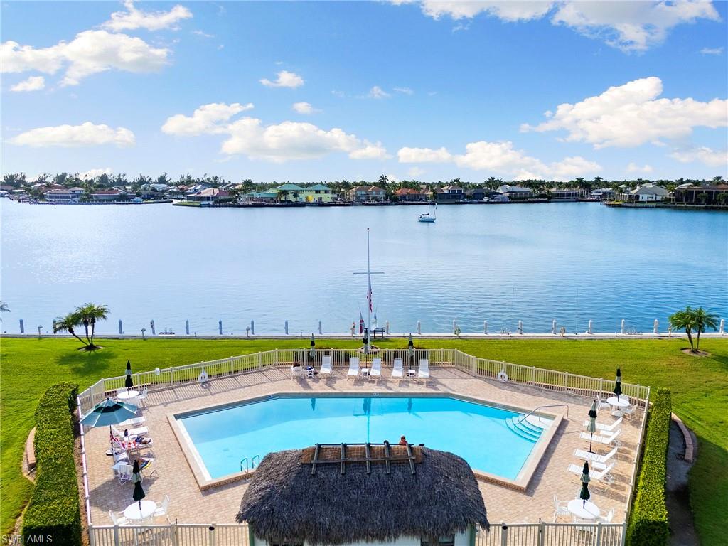 Experience the joy of Marco Island waterfront living in this well-maintained bayfront condo, ideally located near the island's premier dining, shopping, and entertainment of the Esplanade as well as our favorite Farmer's Market. Rest easy; all of the big jobs and special assessments have been taken care of. Offering direct Gulf boating access, this residence is a perfect choice for year-round or seasonal residents, or investors seeking a highly desirable Florida coastal property. Enjoy tranquil bay views from this quiet, complex featuring a waterfront pool overlooking the bay. It creates a resort-style atmosphere just steps from your door. The condo's interior showcases a nicely updated kitchen with granite countertops, stainless steel appliances, and ample cabinetry. Wood-look tile flooring provides a coastal aesthetic that is stylish, durable, and easy to maintain. For added peace of mind, the condo is equipped with impact glass windows and doors, offering enhanced storm protection, security, and energy efficiency. The well-managed community has completed all Milestone inspections and required repairs, adding confidence and long-term value for owners. Located in the wonderful Smokehouse Bay area, it is close to Marco Island's white-sand beaches, marinas, waterfront restaurants, boutiques, and cultural attractions, this condo delivers an exceptional balance of serenity and convenience. Whether you're seeking a full-time residence, vacation retreat, or income-producing property, this Marco Island bayfront condo offers the lifestyle, location, and boating access that buyers are searching for.