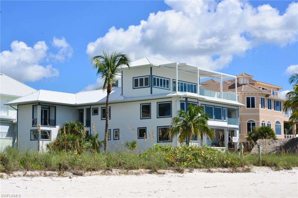Rarely available direct Gulf front home on 1.5 lots in Barefoot Beach. Concrete pilings & part of original structure of main house was incorporated into the new renovated home. The guest house is 100% new construction. Only the finest materials can be found throughout, including porcelain tile & wood flooring, custom cabinetry, exotic level stone countertops throughout, commercial style elevator, exercise room. Kitchen was designed with executive level chef in mind offering separate serving prep area, convenient outdoor grill area & high end appliances including Sub-zero & Thermador. The master suite offers stunning views & includes sitting area, large closet & a spacious bath offering Gulf views. A 4th floor entertaining room includes a built-in bar, folding glass wall & motorized awning. Lower level offers full kitchen & family room. Very rare boardwalk to the beach, flagpole, large beach chickee hut, separate guest cabana with 2 guest suites. A truly fantastic one-of-a-kind home.