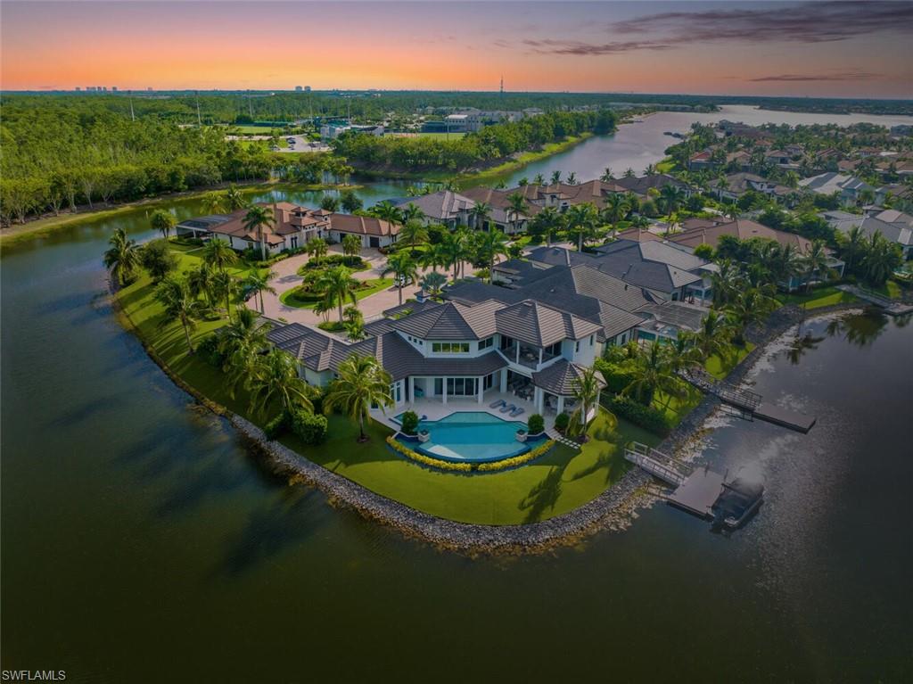 The ultimate waterfront lifestyle awaits in this exclusive Estate property with private dock in Miromar Lakes Beach & Golf Club.  Perfectly designed on a private peninsula waterfront homesite, this magnificent 5-bedroom residence showcases exquisite architectural details. The centerpiece is a soaring, open-concept great room with grand chandelier & lighted 24-foot dual-sided linear gas fireplace. Design features include white oak wood flooring, tongue-and-groove and wood beam ceiling details, designer tile, open concept gourmet kitchen, butler’s pantry, and back-up generator. The primary suite offers a gracious bath with dressing area, 3 walk in closets including a hers dressing room and separate entry. The second-floor with elevator access includes a game room, en suite bedroom, and open-air balcony. The outdoor oasis offers living room, fireplace, cooling system, electric screens, fully turfed yard with sprinkler system, wrap-around bar with grill and resort-style saltwater infinity edge pool, spa, outdoor shower, private dock. Tesla charger, AC garages, and home gym which can be converted back to additional garage. This is the perfect property for a discerning buyer looking to immediately begin enjoying the Miromar Lakes lifestyle and its unparalleled waterfront living. As the only southwest Florida community with miles of beach, boating, golf, and resort-style amenities in one picturesque destination, it offers a truly remarkable lifestyle. Water-ski, paddle board, kayak, sail, or fish on the 700-acre freshwater lake, unwind at the wellness spa, play the Arthur Hills “Signature” championship golf course, hone your tennis, or pickleball skills, or simply relax in the dreamy beachfront cabanas. Located minutes from Southwest Florida International Airport, world-class beaches, shopping, and dining.