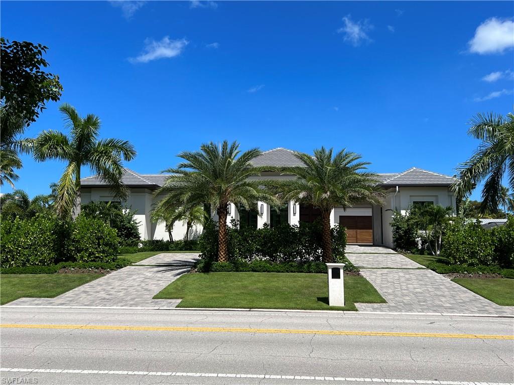 Resort Style living in Parkshore!  Knauf Koenig custom built, Falconer Design, oversized corner lot, 5 bedroom all ensuite baths, custom Ruffino study, attached full bath, and a guest half bath. A unique motor court design with a 2 car AC attached garage. The 3rd car garage attached by porte-cochere was transformed to a complete ac “mother-in-law” suite and bath. Chef inspired kitchen, with custom detailed Ruffino cabinetry, wolf and sub-zero appliances including a 60” wolf range, service kitchen, beverage center, wine room, house generator, house camera’s, house music, lighting system, Legno Bastone wide wood plank flooring, marble, quartzite, extensive custom millwork, exquisite interior finishes. Open floorplan with private Parlor, 3 sets of sliding doors open to resort style outdoor living with southern exposure. Outdoor fireplace and 2 living areas, dining and outdoor kitchen. Extensive lanai surround resort pool and spa, stairs down to firepit relaxation area, tropical landscape and large grass lawn for family fun & pets. Walk to the beach, and the private Parkshore beach membership available. Walk to Waterside shops and Venetian Village. Designer furnished, ready to move in.
