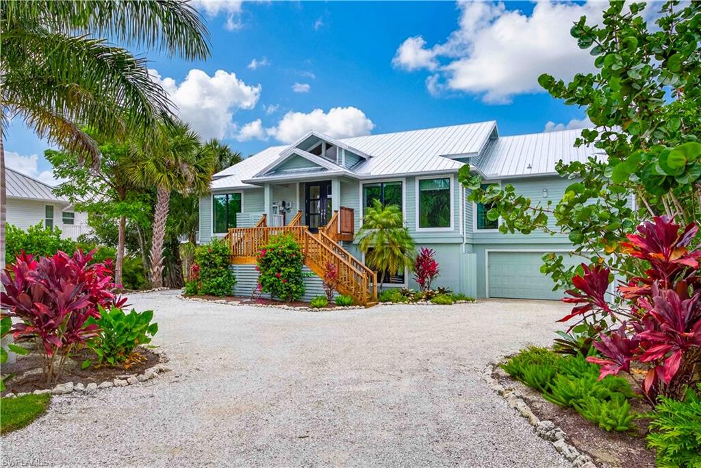 Cool, calm, and coastal, this beautiful island-inspired home is ideally situated in the prestigious Gulf Ridge beach community. Enjoy sun-filled days at the beach and unwind in the evenings by your private tropical pool oasis. Offering over 3,000 square feet of living space, the home features a thoughtfully designed split-bedroom floor plan with expansive living and dining areas overlooking the elevated, screened pool.

The great room is the heart of the home, highlighted by a striking coral stone fireplace, wet bar, and an open entertainer’s kitchen. A casual dining area invites family and friends to gather with ease.

Surrounding the pool, the covered lanai creates an exceptional outdoor living environment designed for both entertaining and relaxation. Accessible from the great room, living room, and primary suite, this space includes pool bath access, an extensive covered area, an outdoor bar, and a pass-through kitchen—perfect for spending the day in true island style.  4 bedrooms include a delightful owner's suite with a freestanding soaking tub and luxurious shower, dual sinks and tremendous storage.  The owner has connected the 4th bedroom to create a dressing and staging area. 

The unfinished lower level offers abundant storage for bikes, beach gear, and hobbies, along with a three-car tandem garage.

Recent upgrades include a new metal roof, remodeled kitchen and primary bath, renovated guest bath, impact windows, fresh interior and exterior paint, new front doors, an elevator lift at the entry, and extensive new landscaping that creates a lush tropical garden setting.

Gulf Ridge is known for its incredible landscapes and beautifully maintained grounds.  FOUR PRIVATE beach access points including 2 that accommodate ATV's.  2 community pools, tennis courts, and a kayak launch into Old Blind Pass and Bowman's beach